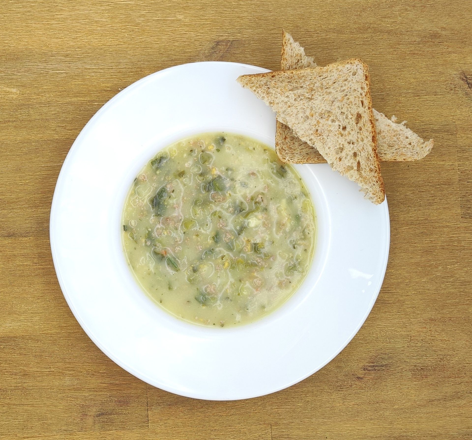 Eine ausgestopfte Raupe mit Kochmütze neben einem Teller mit der Aufschrift „Bild folgt“.