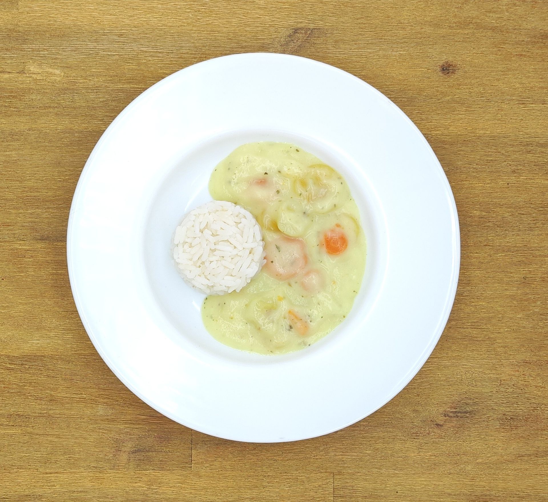 Weißer Teller mit Farfalle-Nudeln und Orangensauce, bestreut mit geriebenem Käse.