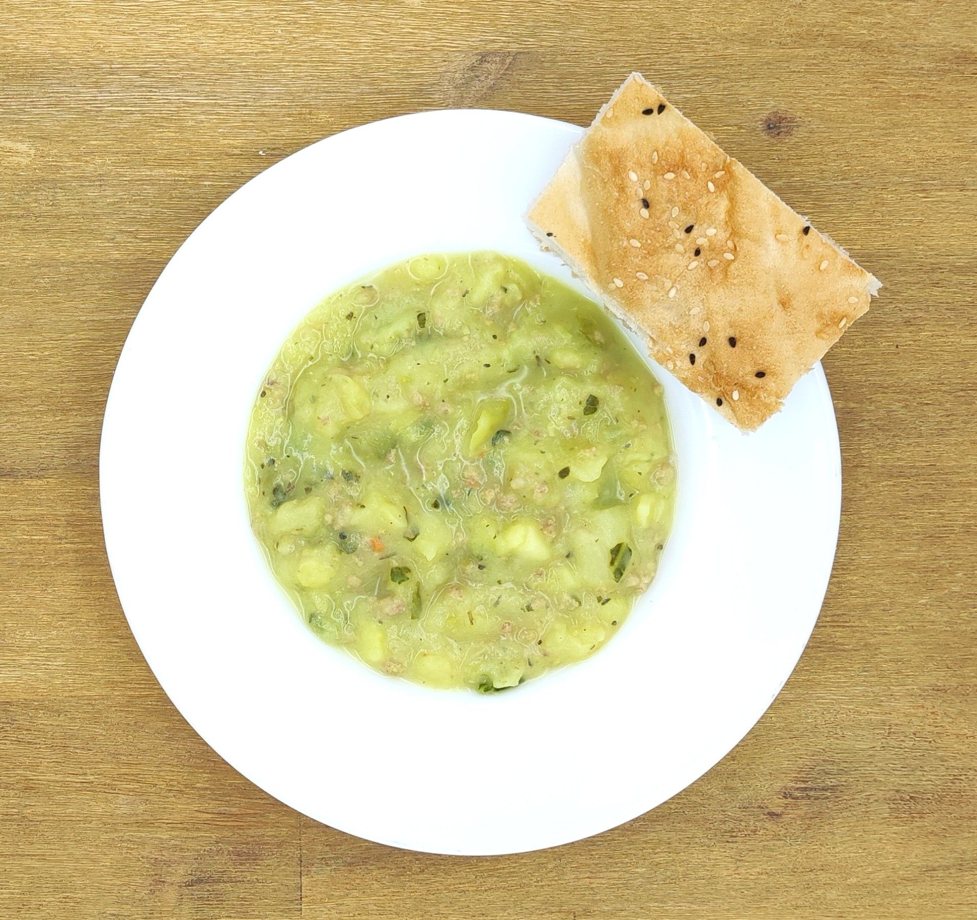 Eine ausgestopfte Raupe mit Kochmütze neben einem Teller mit der Aufschrift „Bild folgt“.