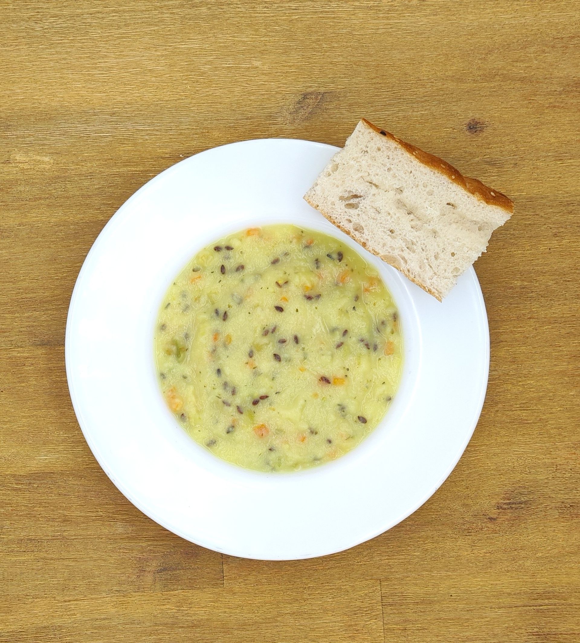 Weißer Teller mit Farfalle-Nudeln und Orangensauce, bestreut mit geriebenem Käse.
