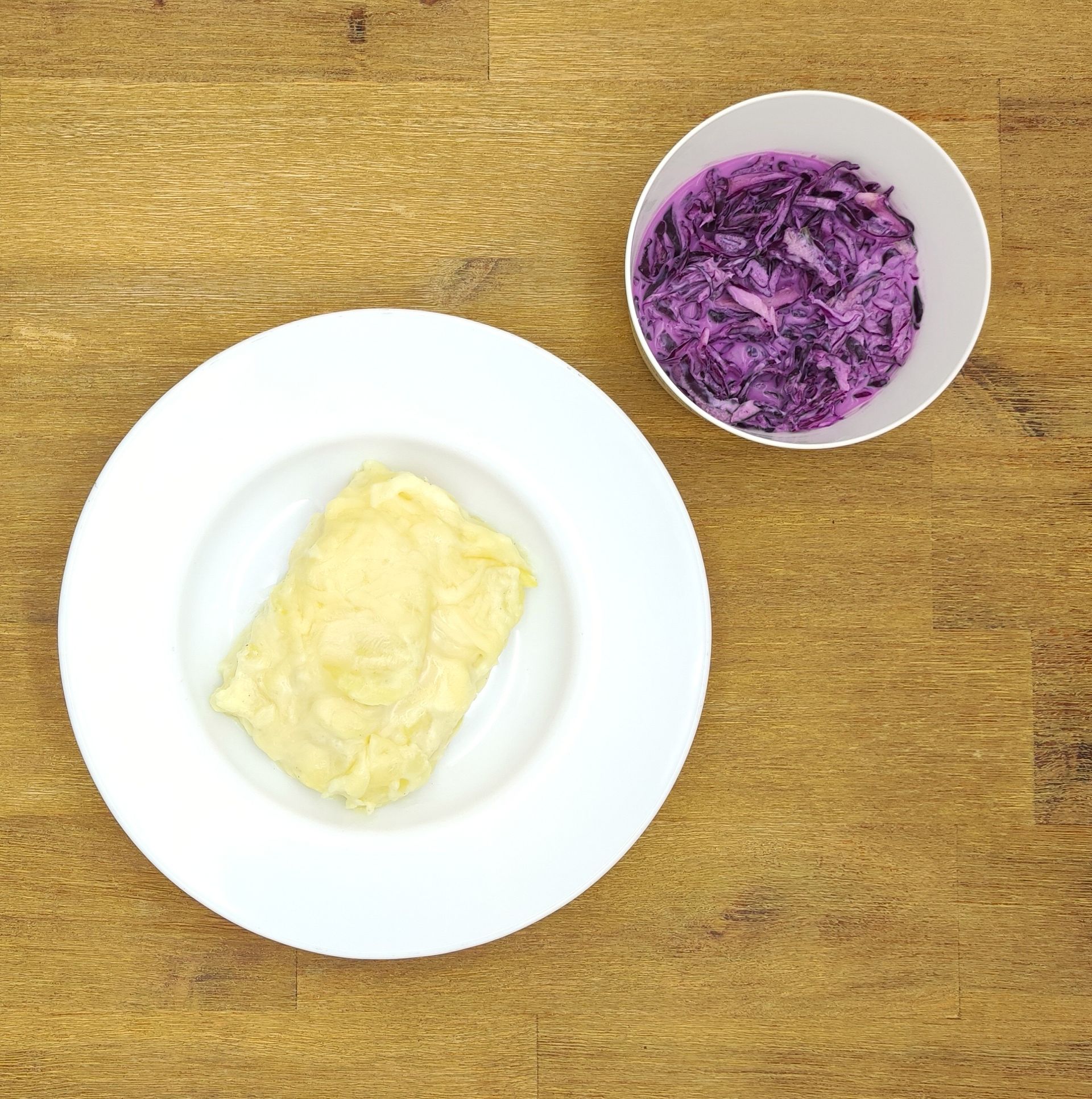 Eine ausgestopfte Raupe mit Kochmütze neben einem Teller mit der Aufschrift „Bild folgt“.