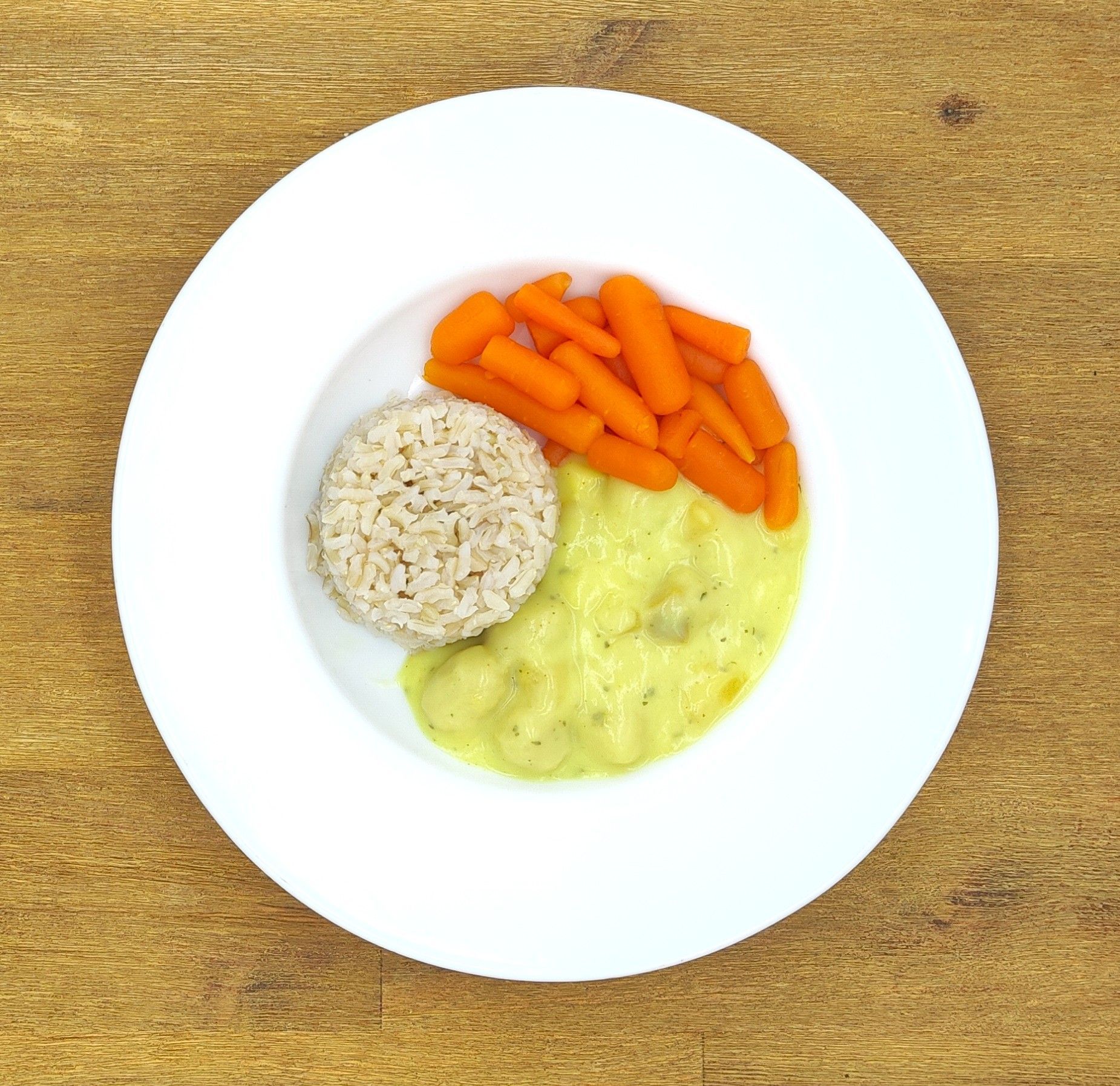 Teller mit Karotten, Reis und Soße.