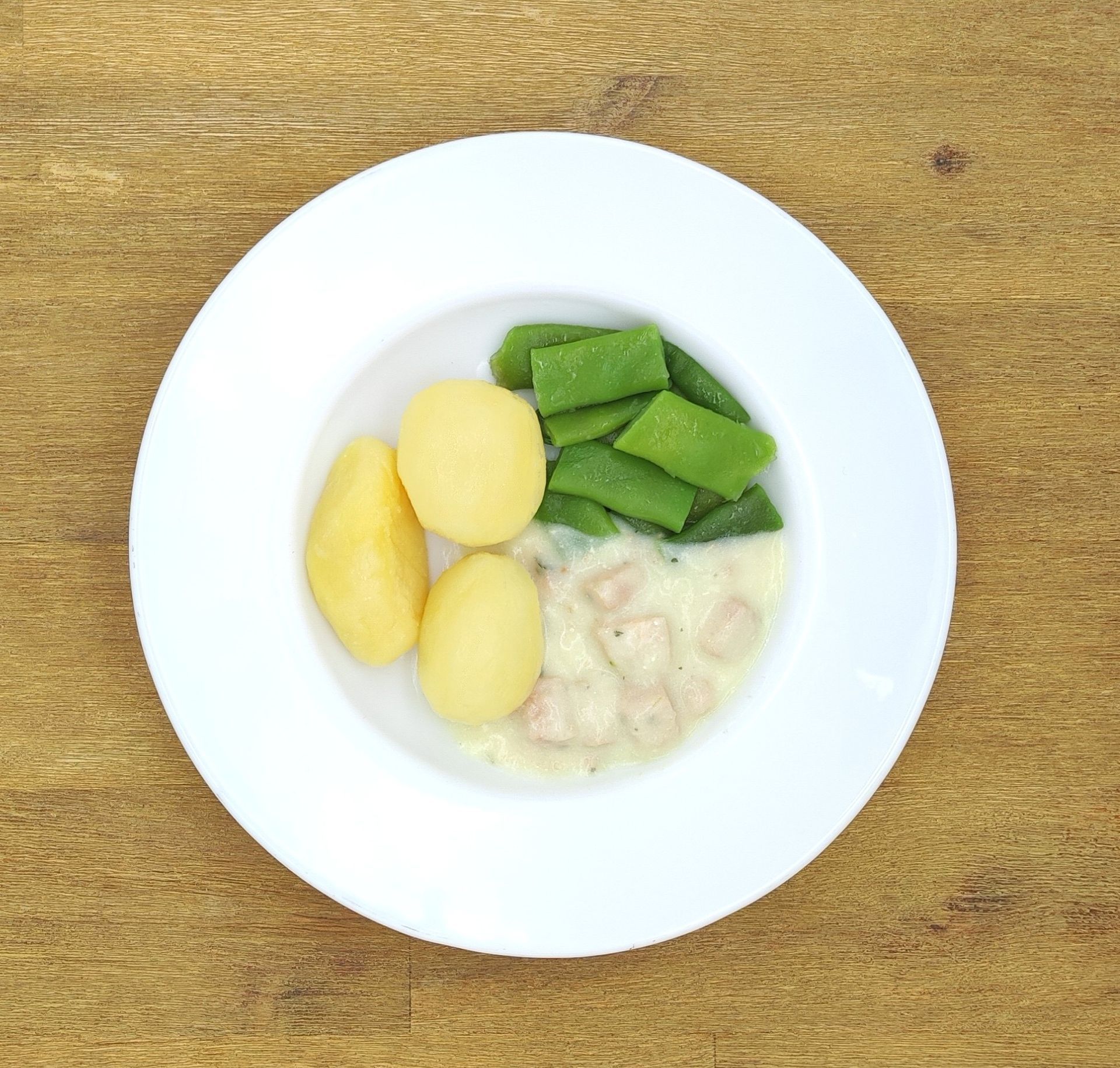 Eine ausgestopfte Raupe mit Kochmütze neben einem Teller mit der Aufschrift „Bild folgt“.