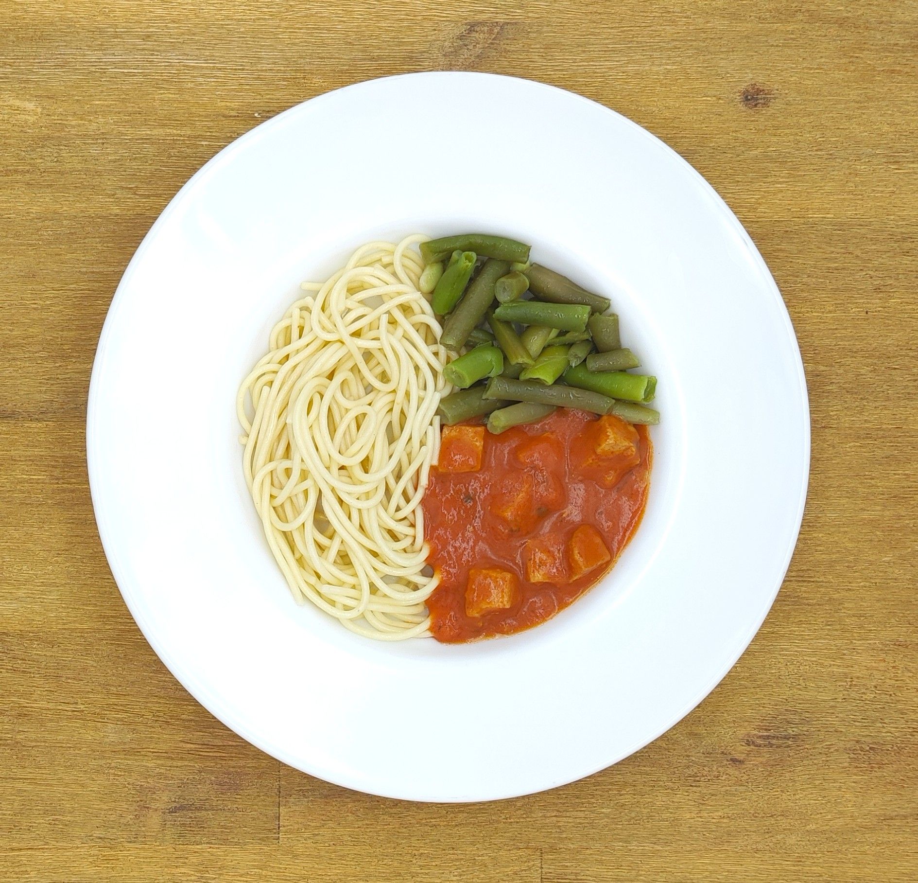 Eine ausgestopfte Raupe mit Kochmütze neben einem Teller mit der Aufschrift „Bild folgt“.