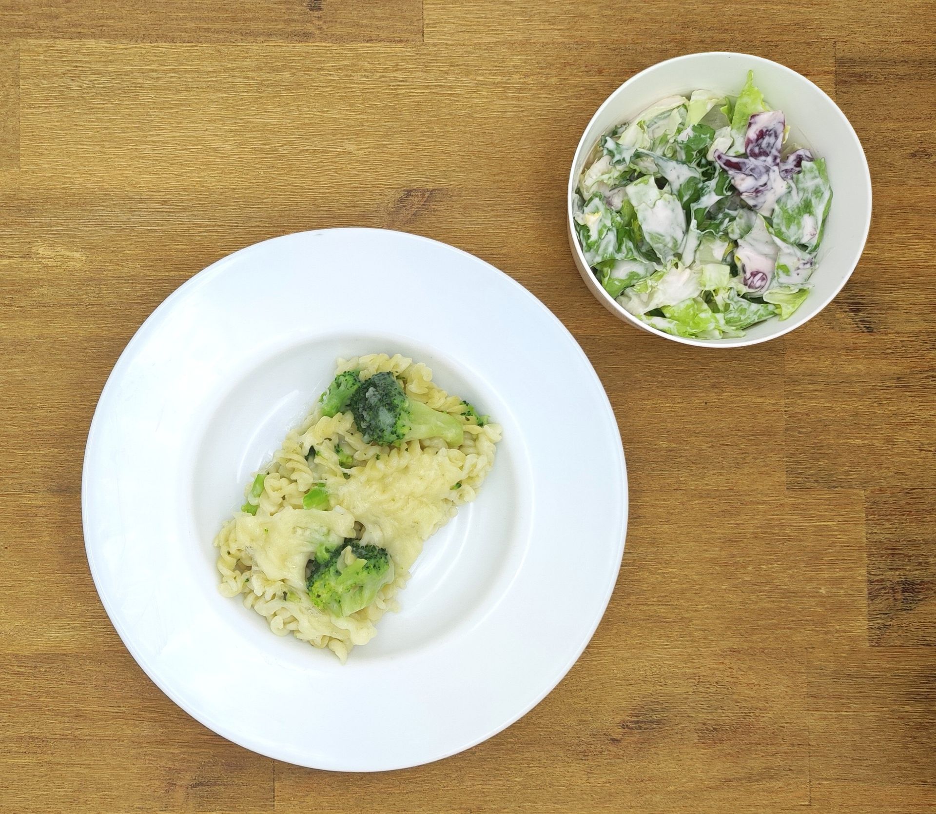 Eine ausgestopfte Raupe mit Kochmütze neben einem Teller mit der Aufschrift „Bild folgt“.