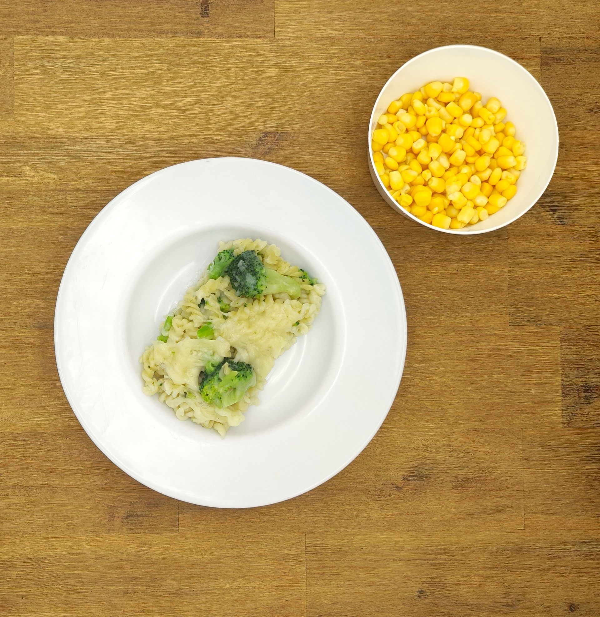 Eine ausgestopfte Raupe mit Kochmütze neben einem Teller mit der Aufschrift „Bild folgt“.