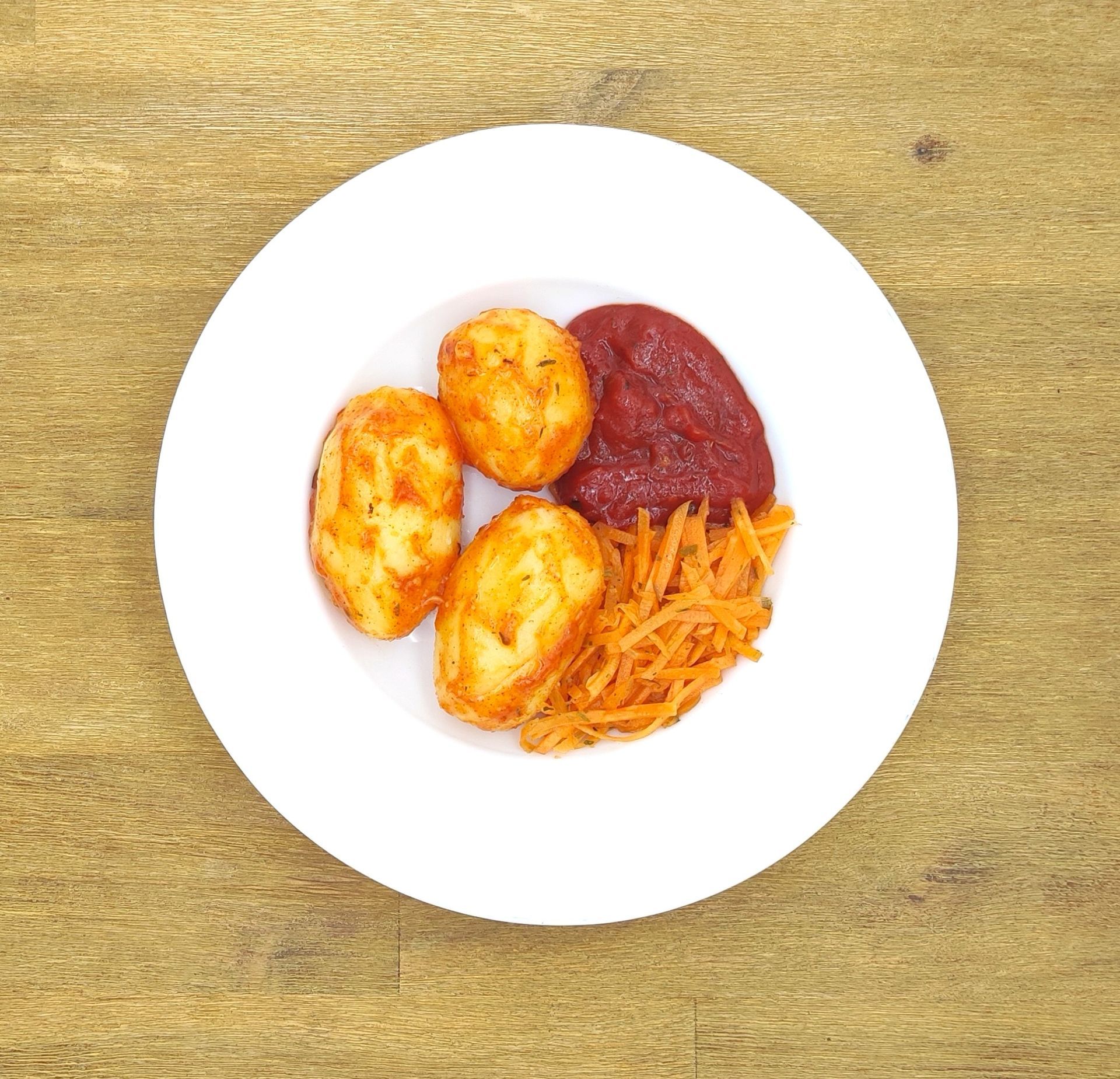 Weißer Teller mit Farfalle-Nudeln und Orangensauce, bestreut mit geriebenem Käse.