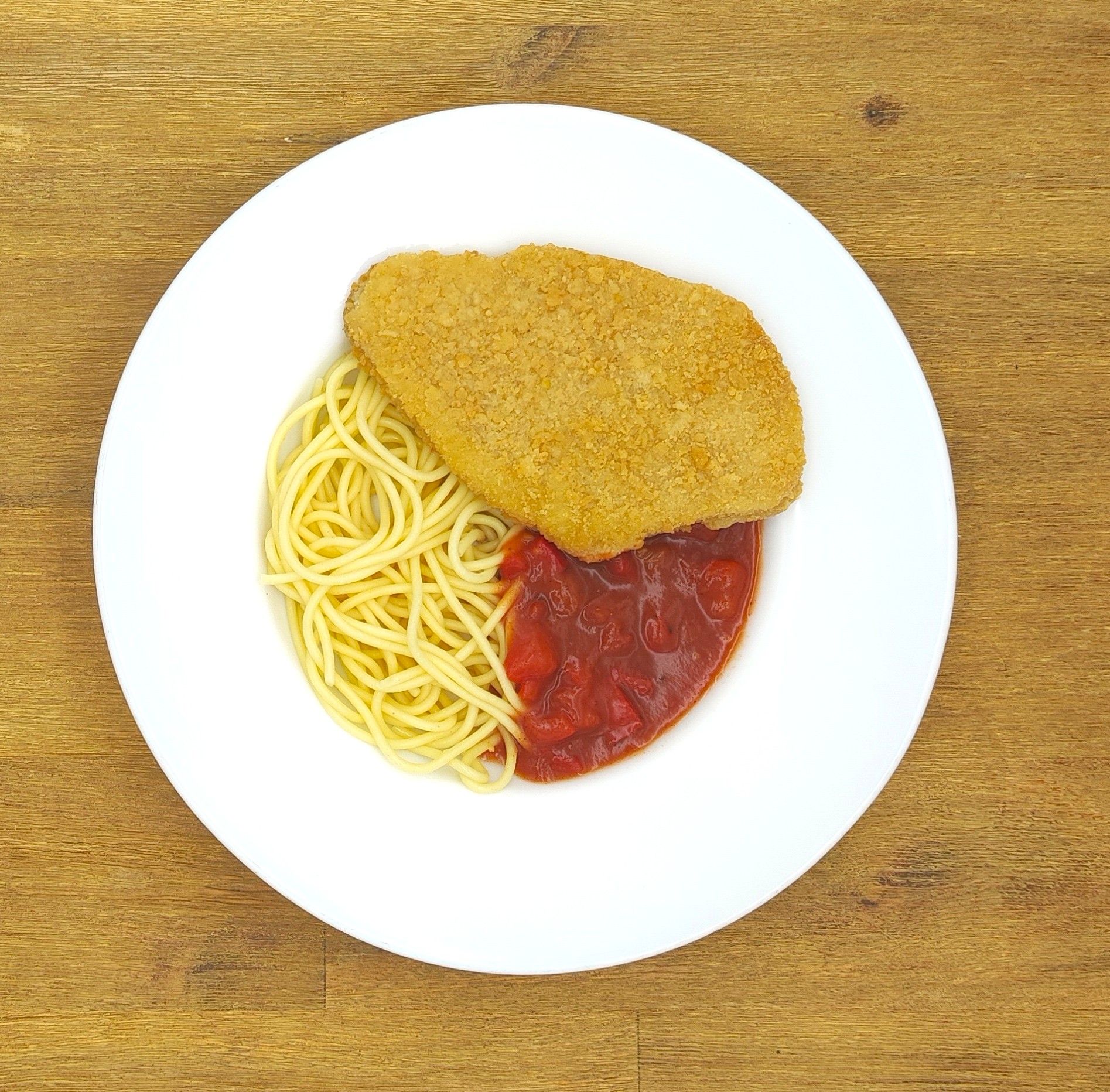 Hähnchen-Parmesan mit Spaghetti und Tomatensoße auf einem weißen Teller.