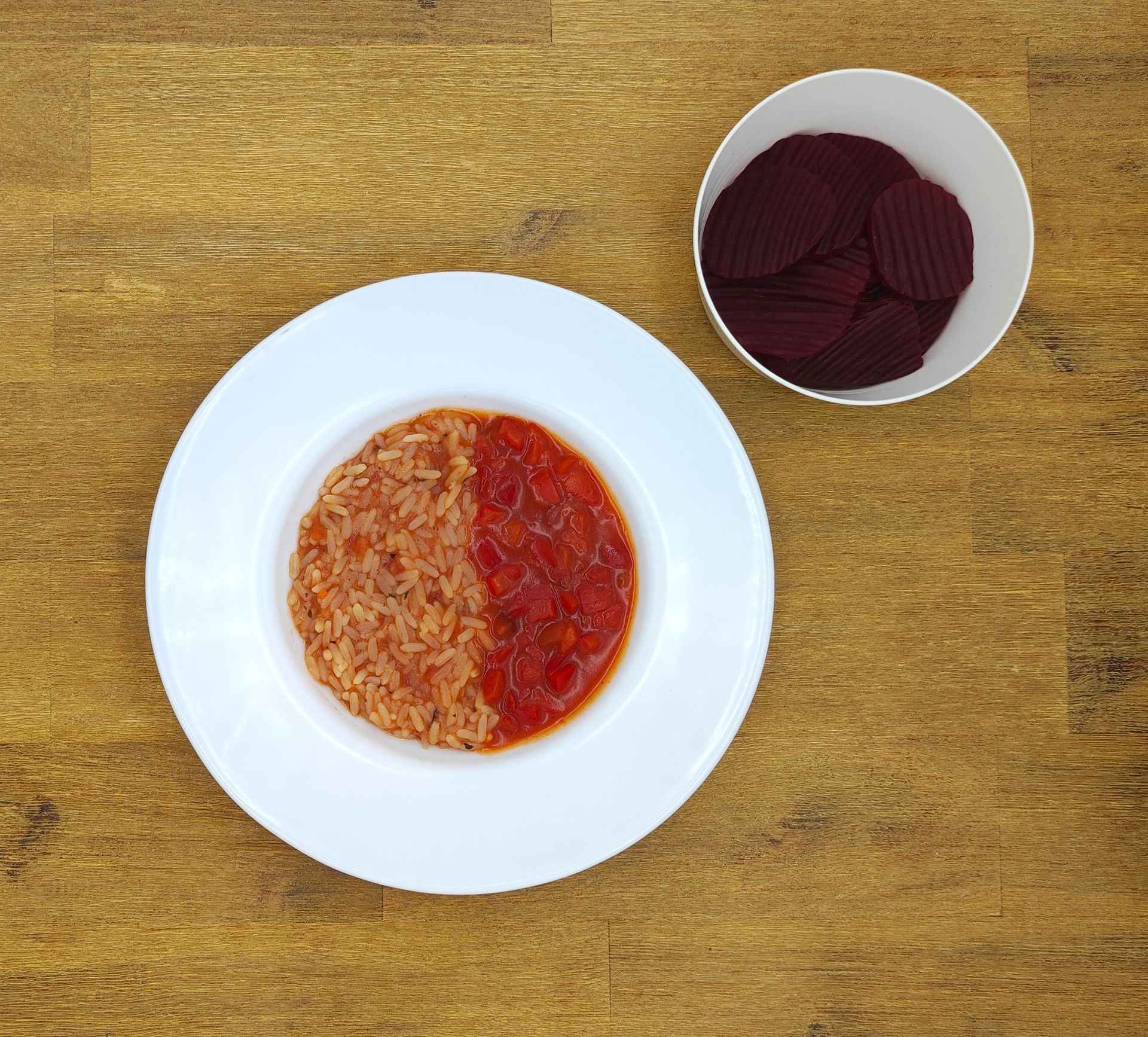 Teller mit Reis und Tomatensoße mit Rote-Bete-Chips.