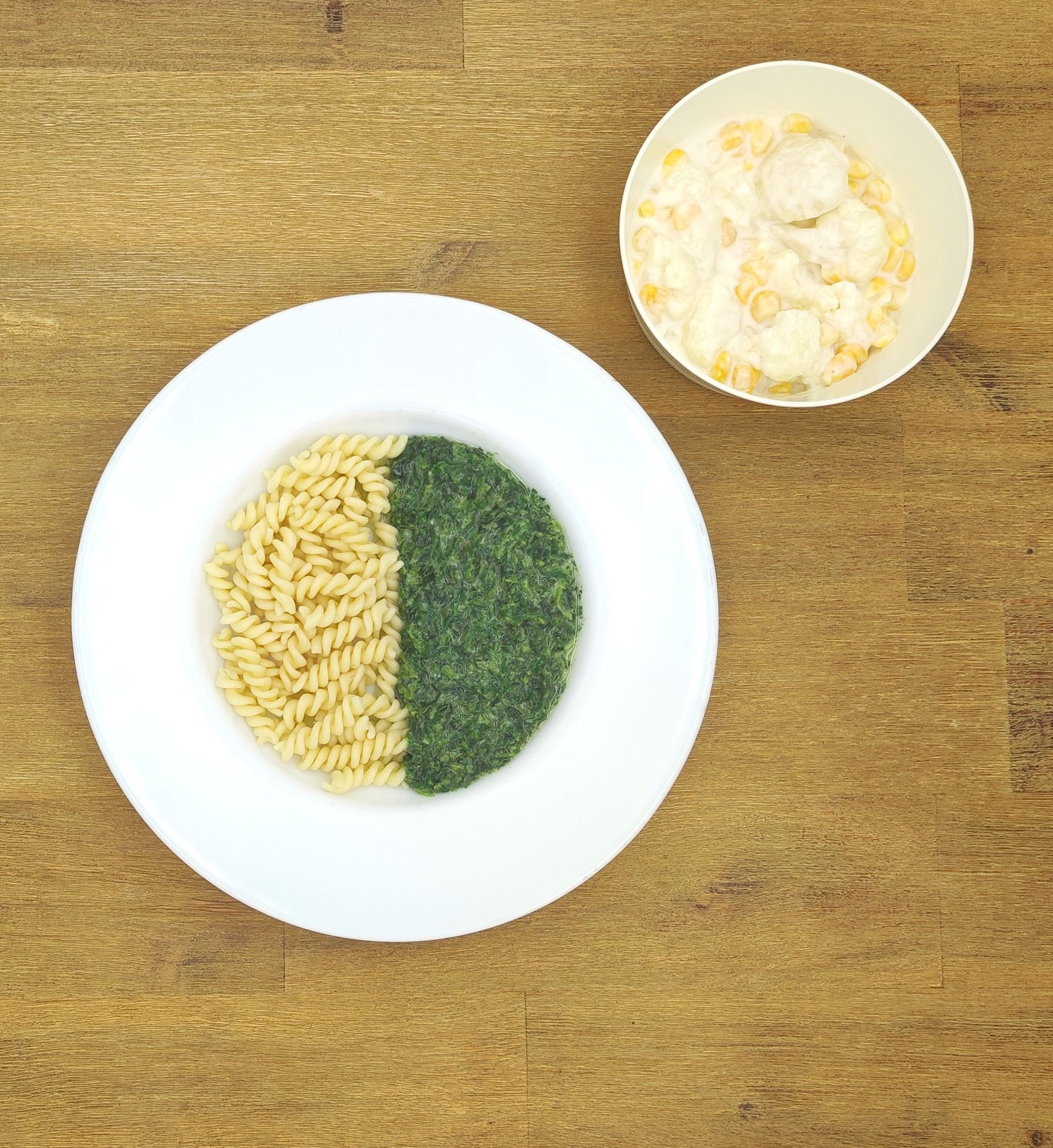 Eine ausgestopfte Raupe mit Kochmütze neben einem Teller mit der Aufschrift „Bild folgt“.