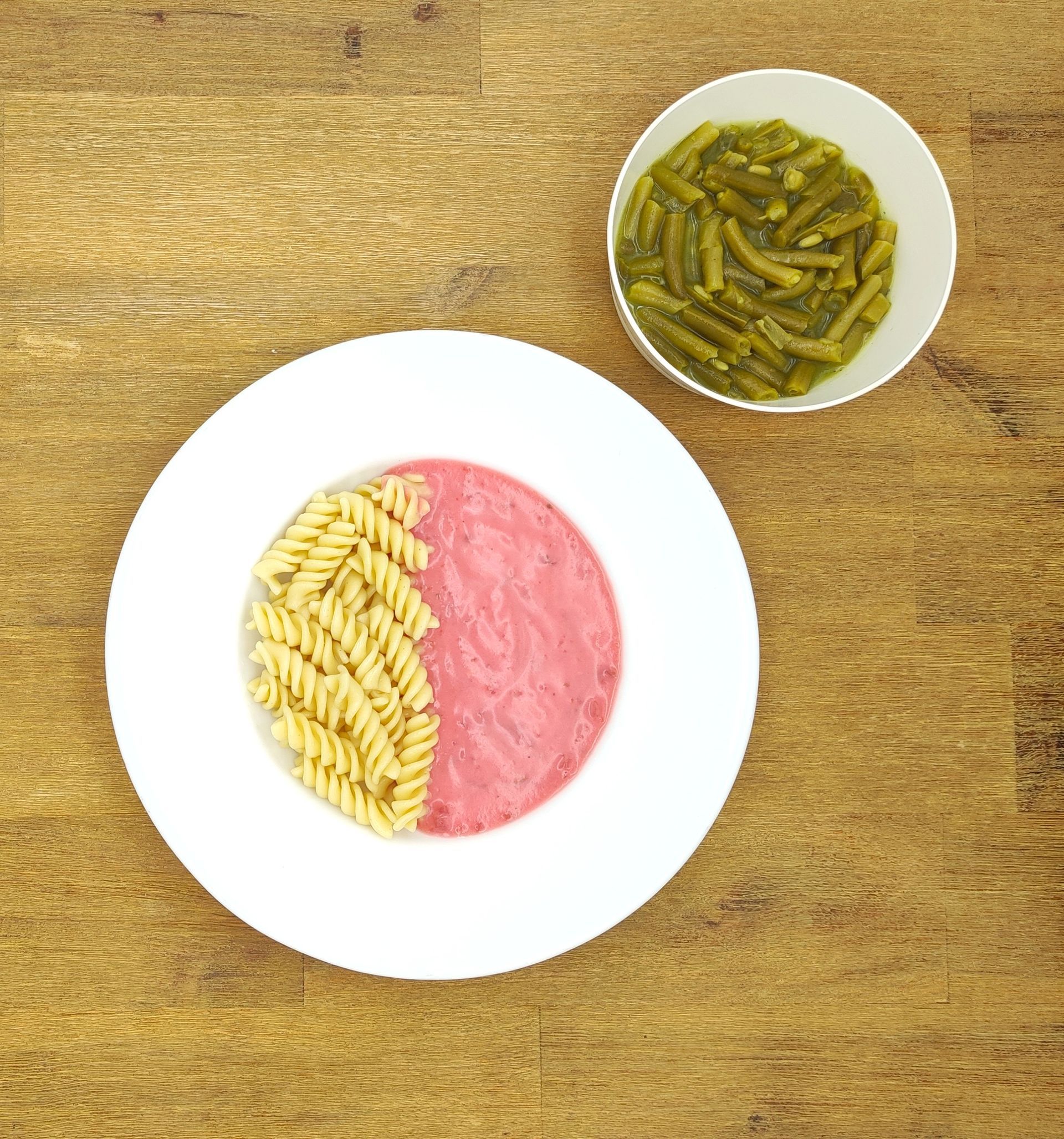 Eine ausgestopfte Raupe mit Kochmütze neben einem Teller mit der Aufschrift „Bild folgt“.