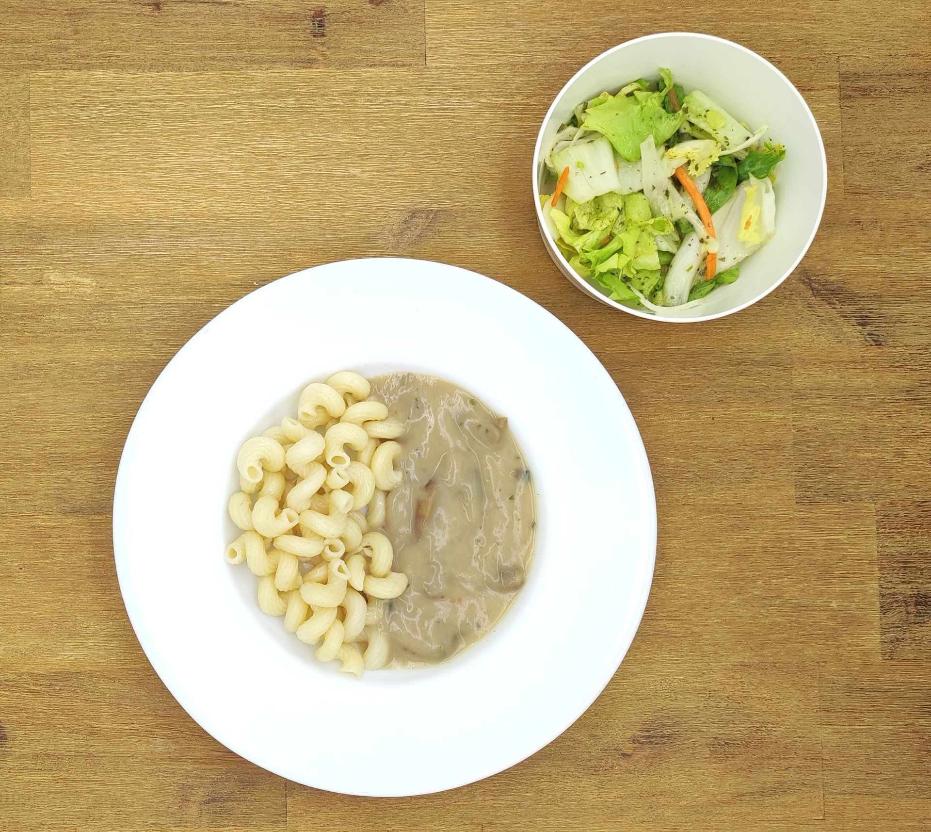 Eine ausgestopfte Raupe mit Kochmütze neben einem Teller mit der Aufschrift „Bild folgt“.