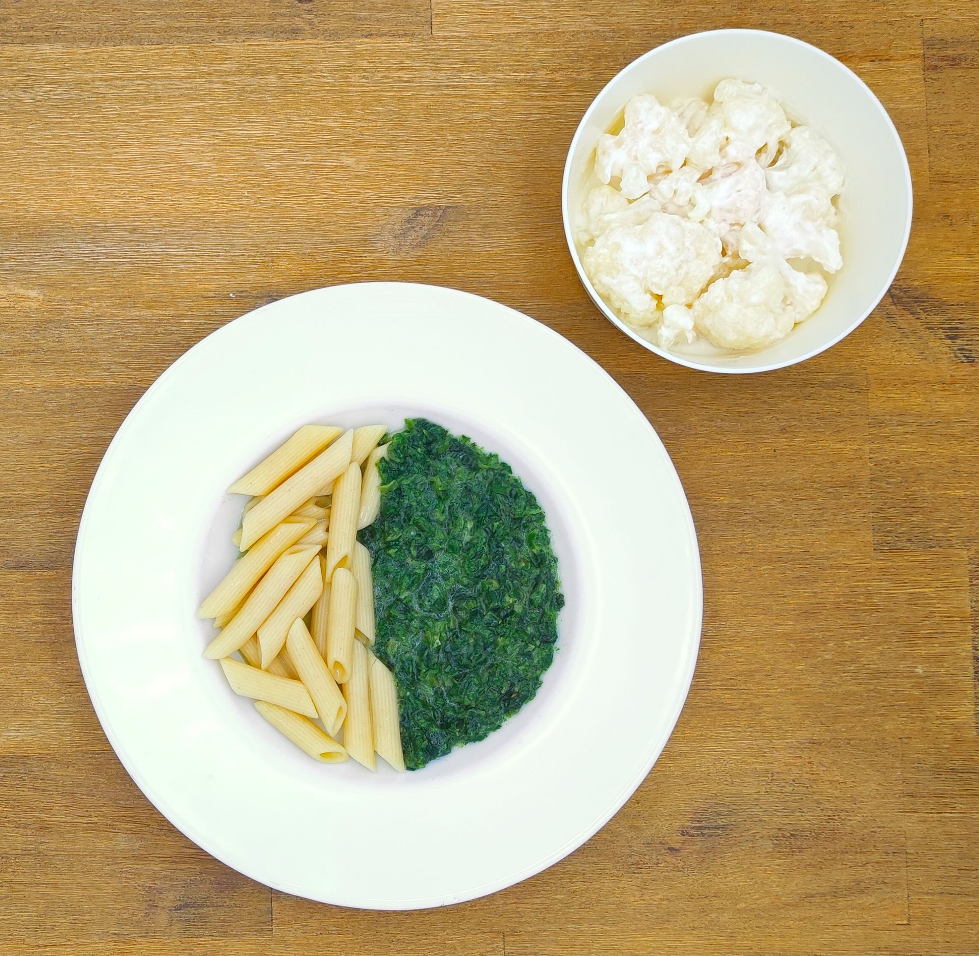 Eine ausgestopfte Raupe mit Kochmütze neben einem Teller mit der Aufschrift „Bild folgt“.