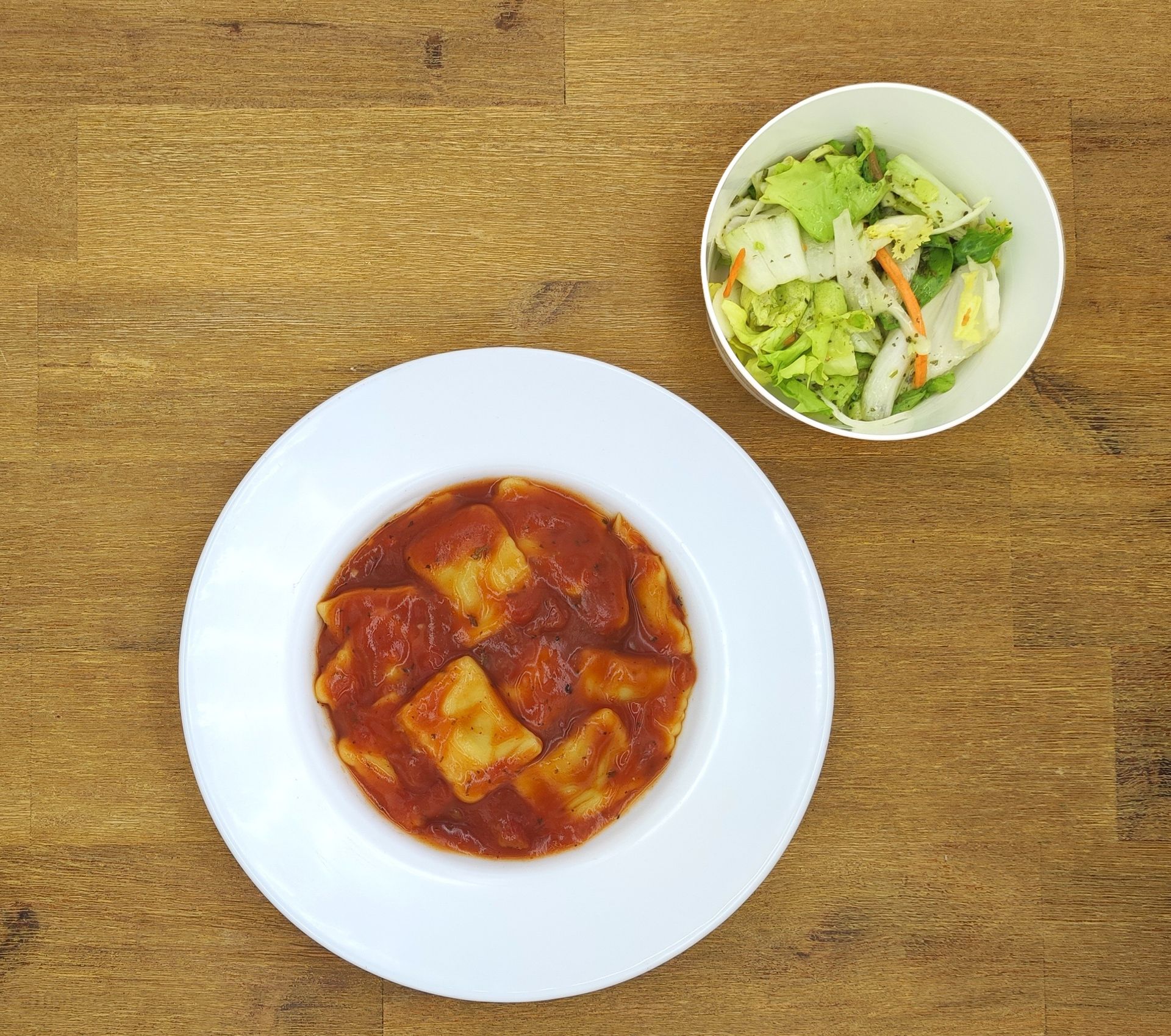 Eine ausgestopfte Raupe mit Kochmütze neben einem Teller mit der Aufschrift „Bild folgt“.