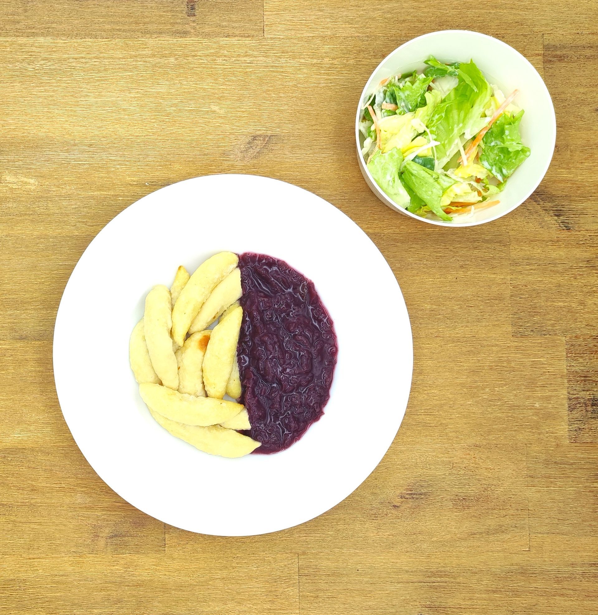 Eine lächelnde Raupe mit Kochmütze neben einem Teller mit der Aufschrift „Bild folgt“.