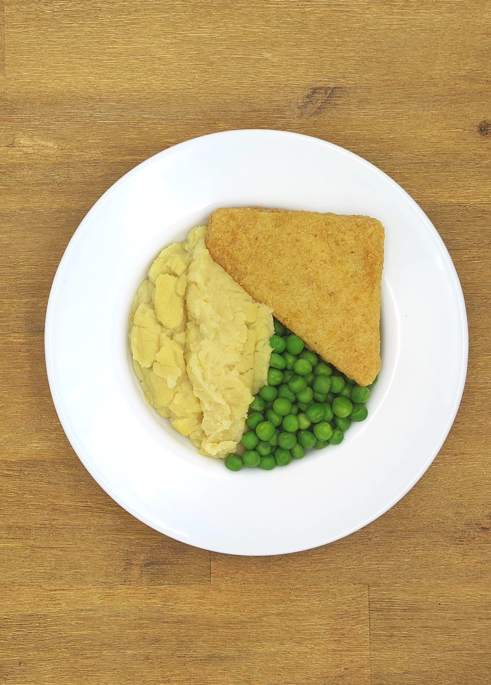 Auf einem weißen Teller mit Apfelmus lagen Crêpes auf einem Holztisch.