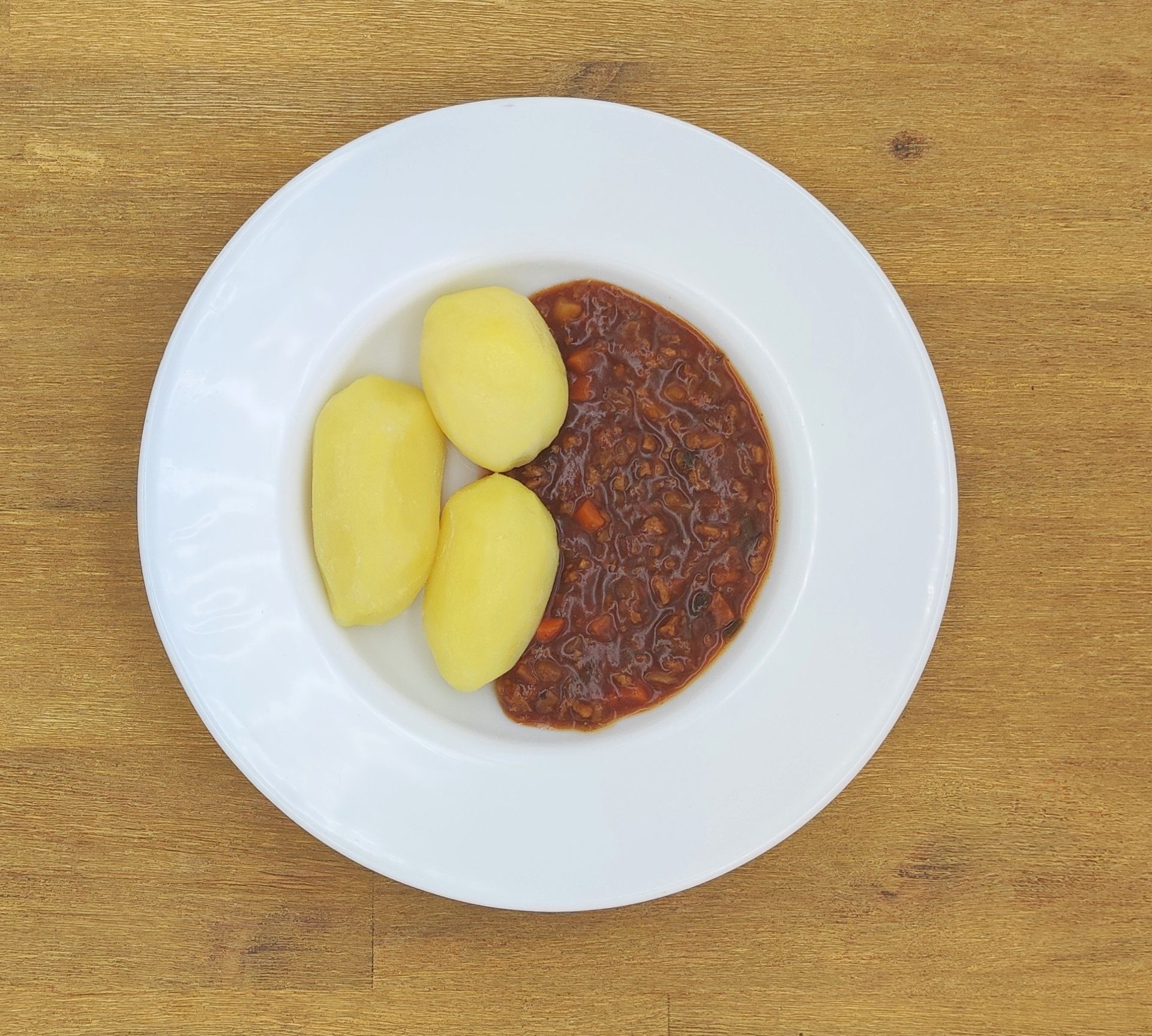 Eine ausgestopfte Raupe mit Kochmütze neben einem Teller mit der Aufschrift „Bild folgt“.