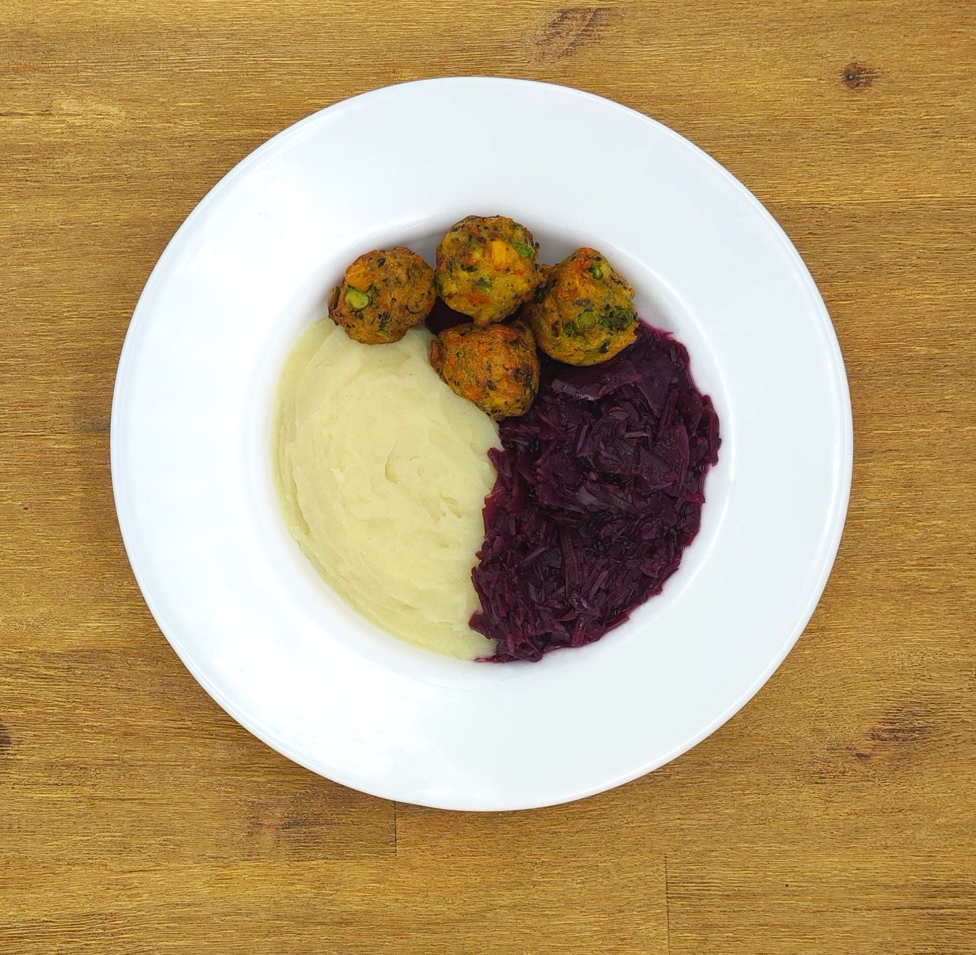 Weißer Teller mit Farfalle-Nudeln und Orangensauce, bestreut mit geriebenem Käse.