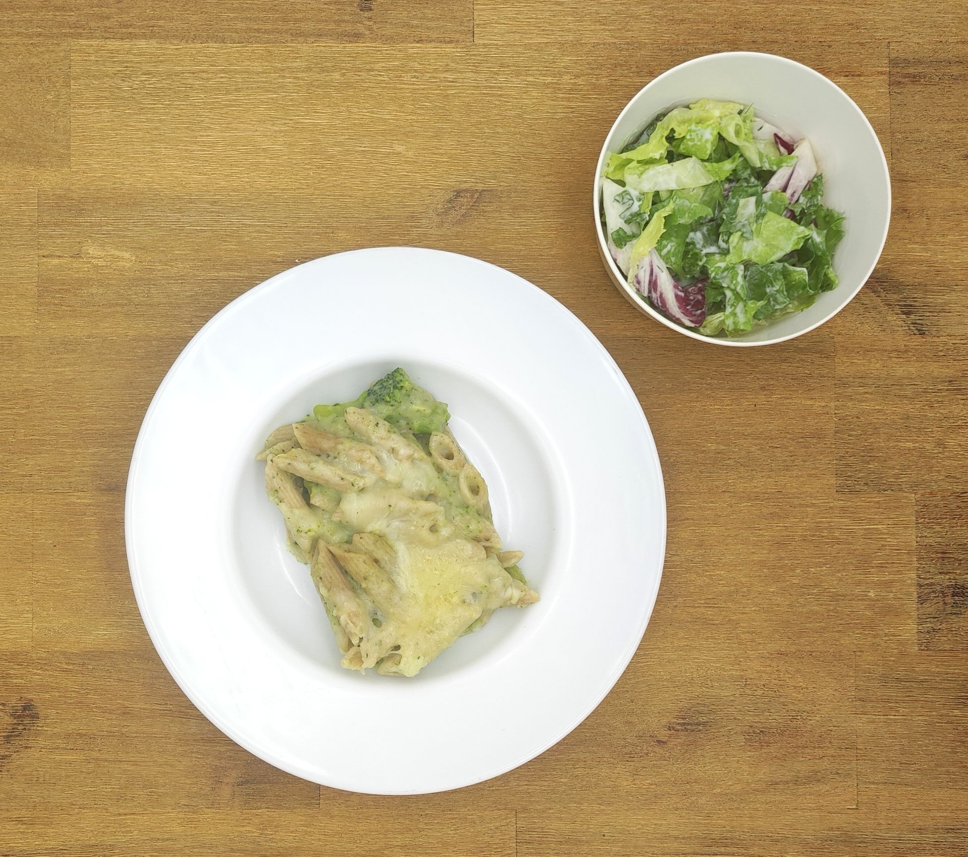 Eine ausgestopfte Raupe mit Kochmütze neben einem Teller mit der Aufschrift „Bild folgt“.