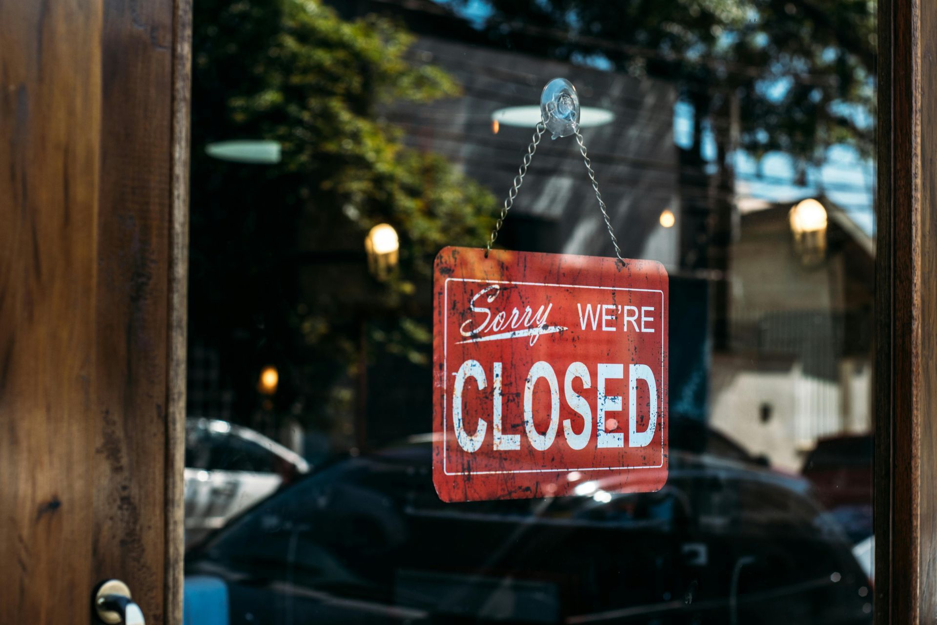 In einem Fenster hängt ein rot-weißes Schild mit der Aufschrift „Sorry, We're Closed“; 