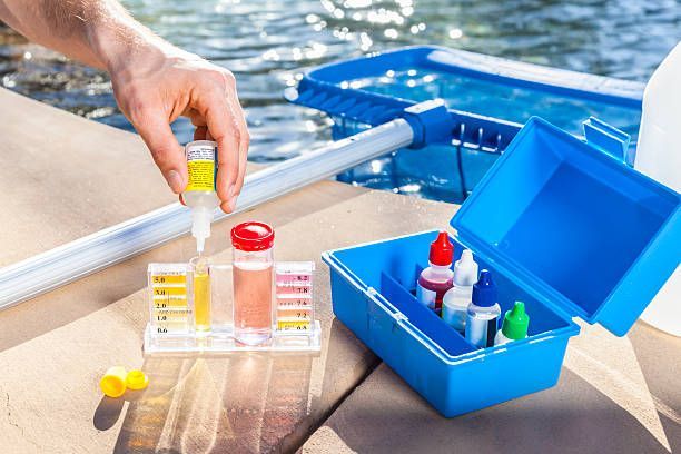 Testing swimming pool water chemical levels.
