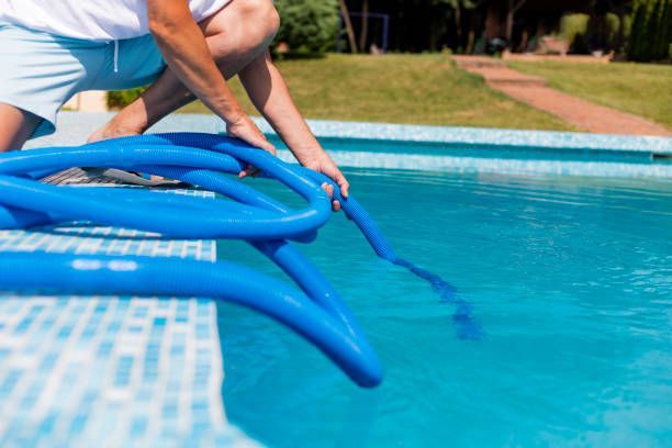 Professional connecting a blue pool vacuum hose.