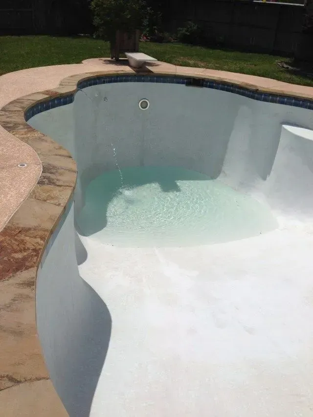 Fully drained concrete inground swimming pool.