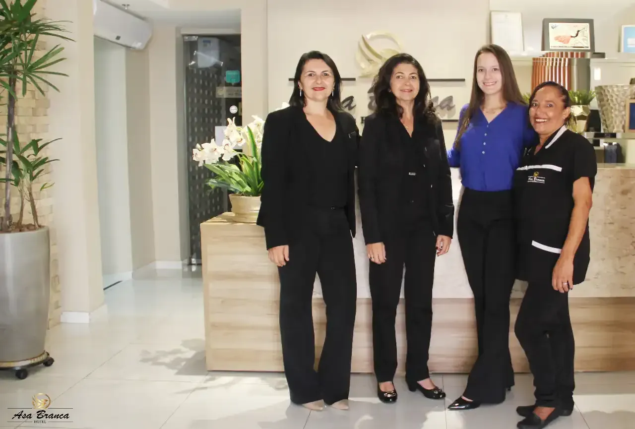 Um grupo de mulheres está posando para uma foto em frente a um balcão.hotel-asa-branca