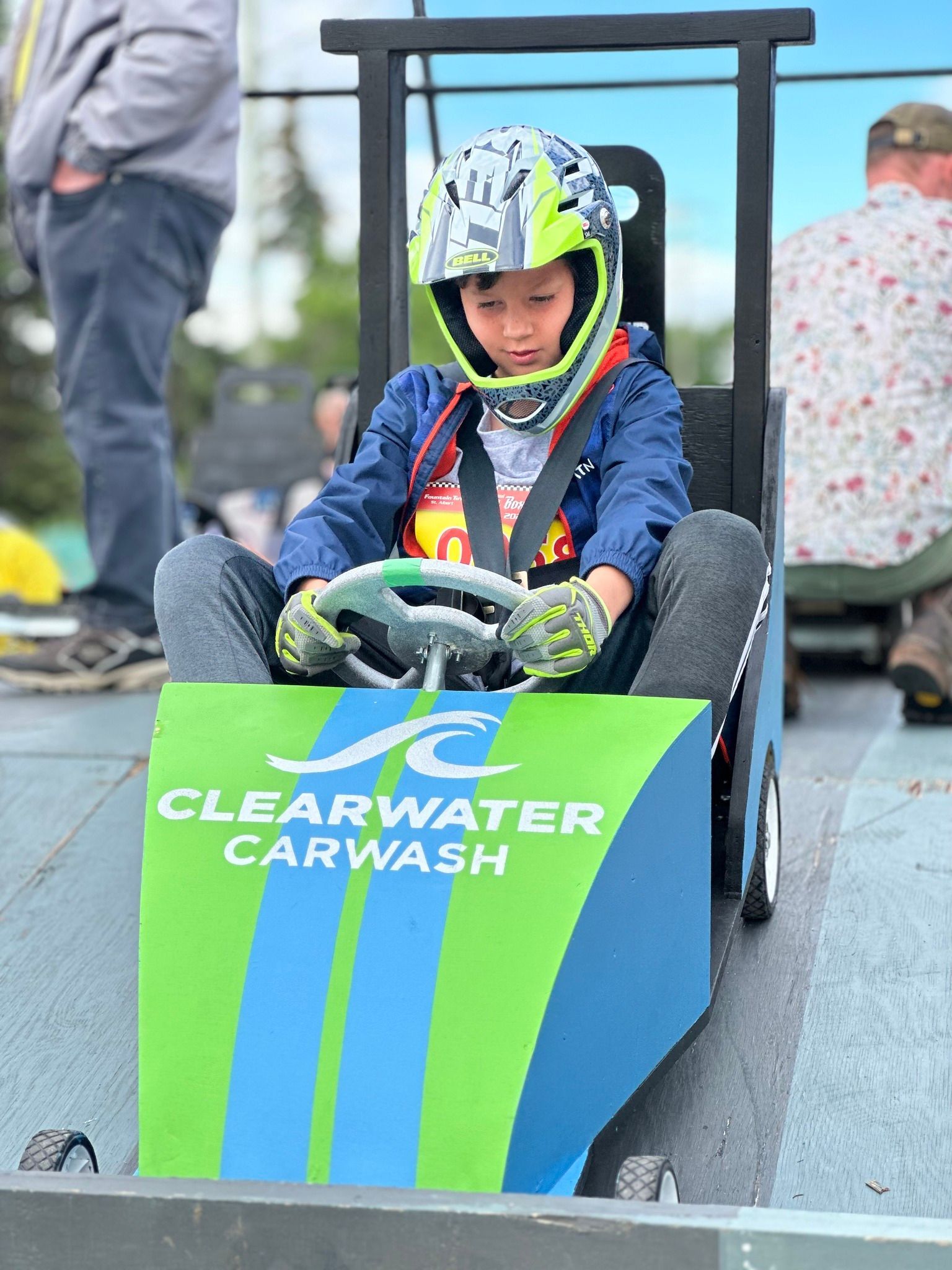Boy in soap box car showing ClearWater CarWash logo
