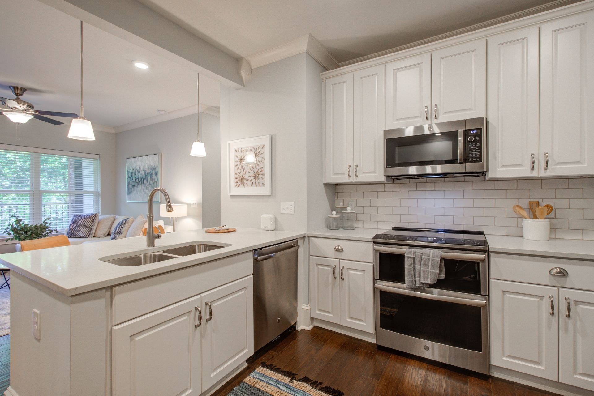 Modern kitchen with white cabinets, stainless steel appliances, and island.