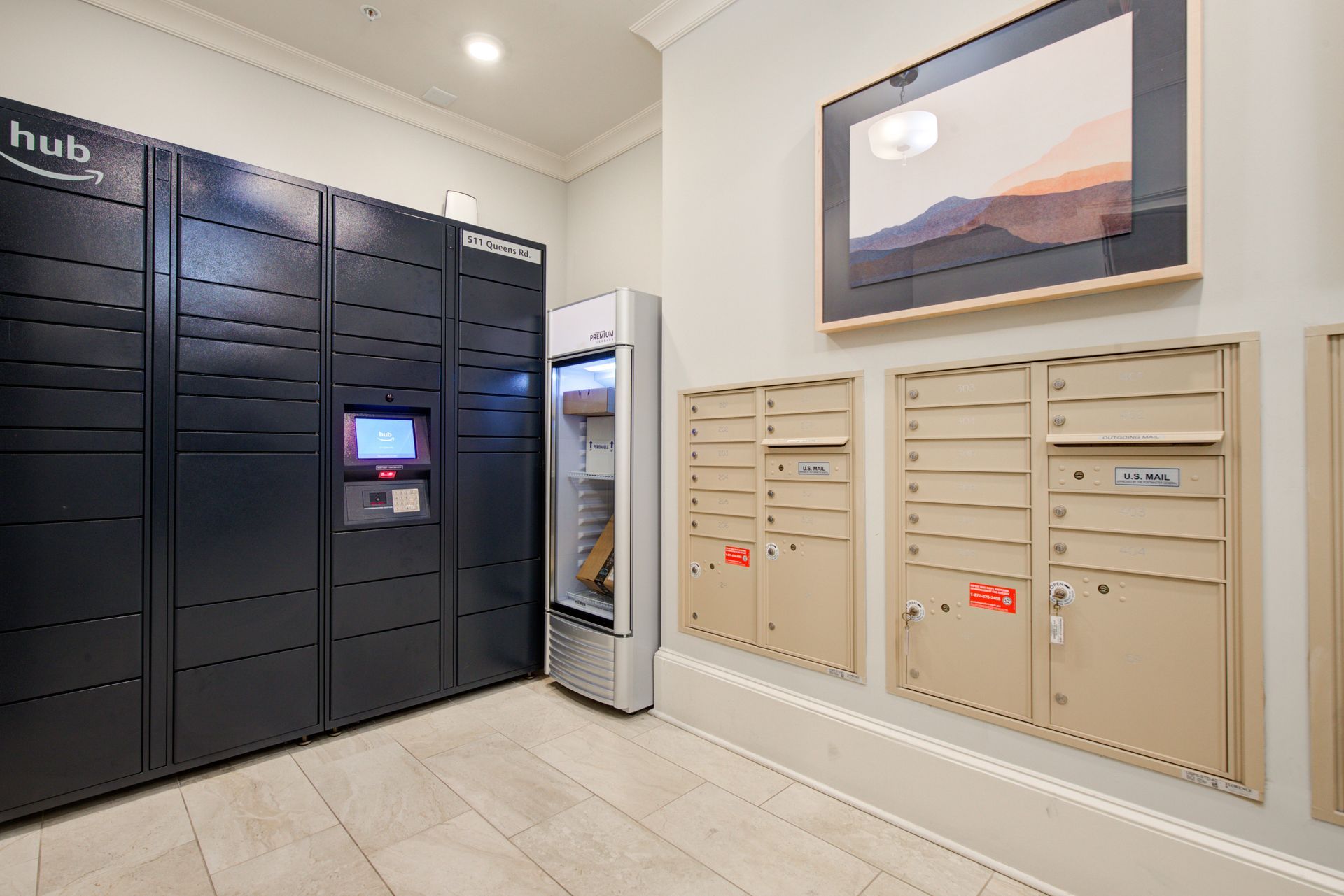Apartment lobby with Amazon Hub lockers, mailboxes, and a framed artwork.
