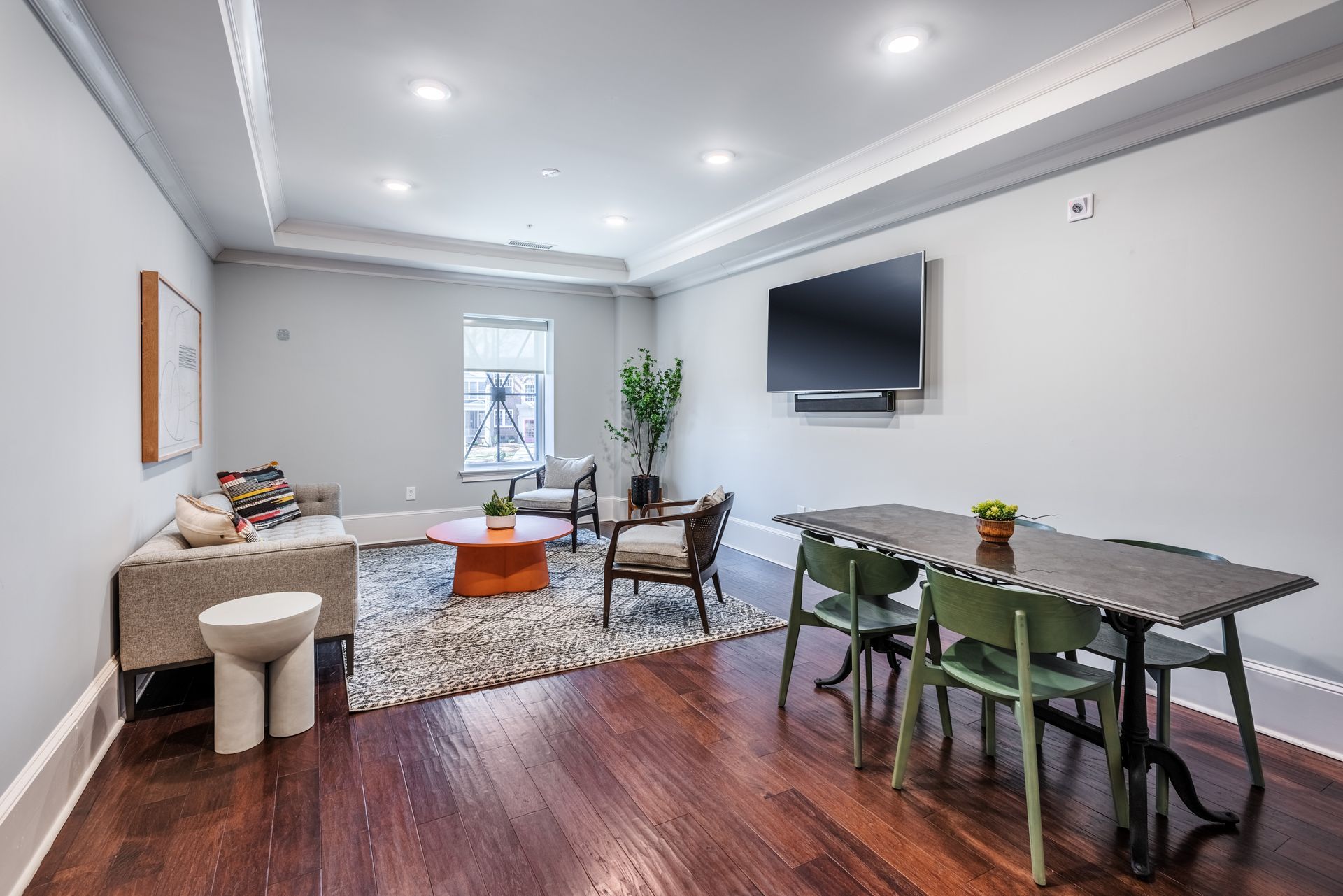 Living room with sectional sofa, dining table, and mounted TV.