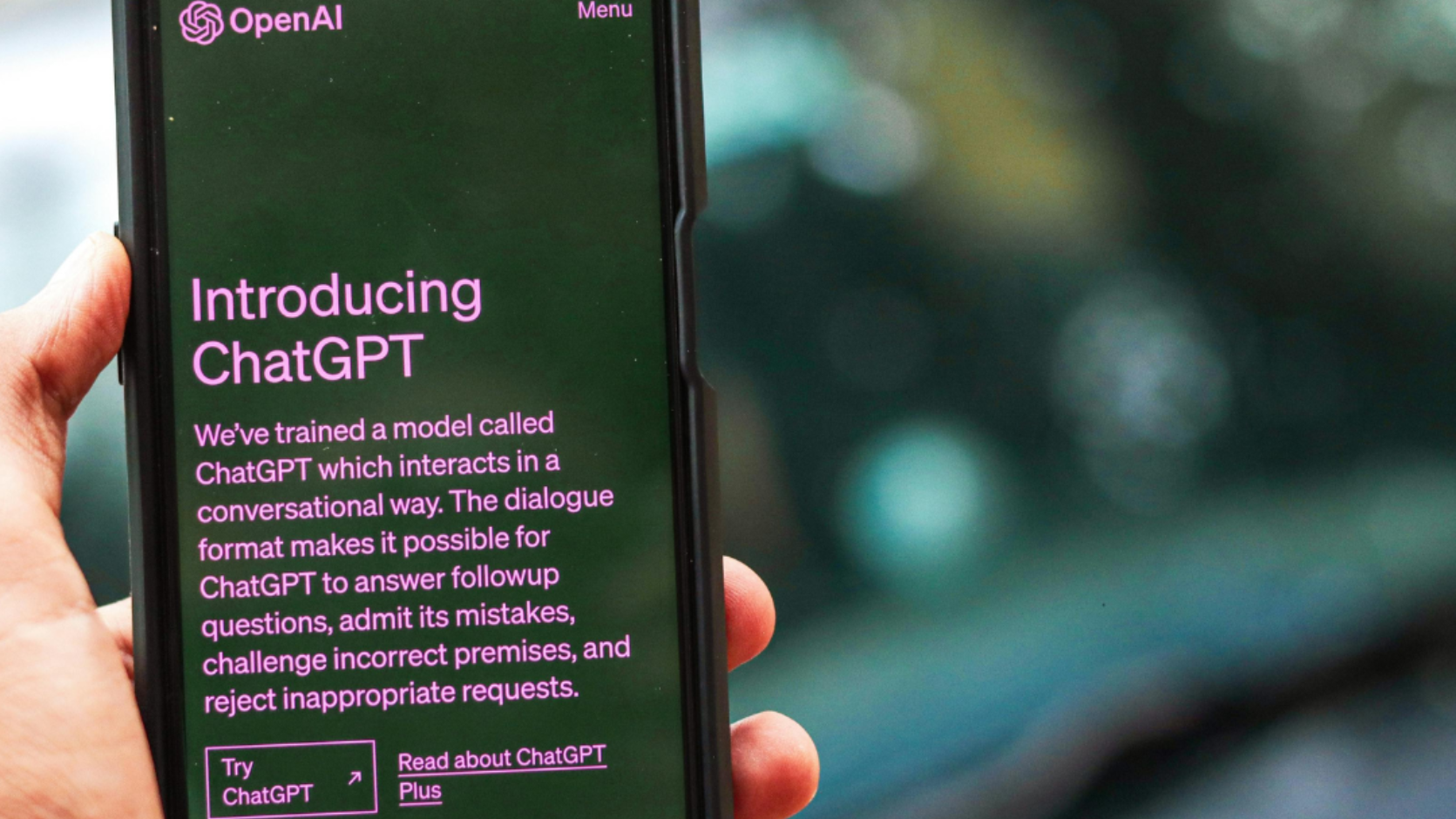 A person is holding a cell phone with a graph on the screen.