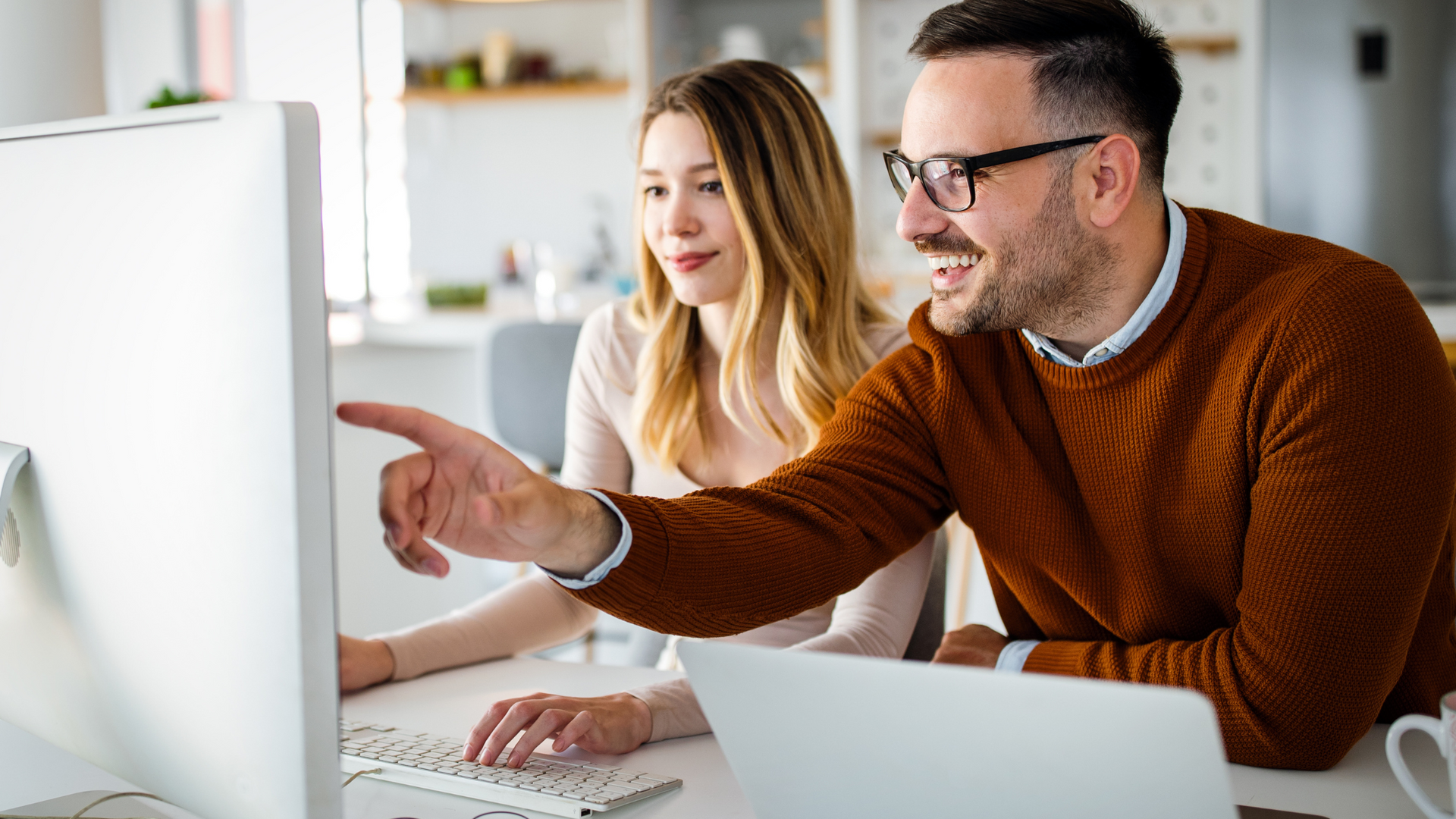 Two people working on a project for their marketing agency.