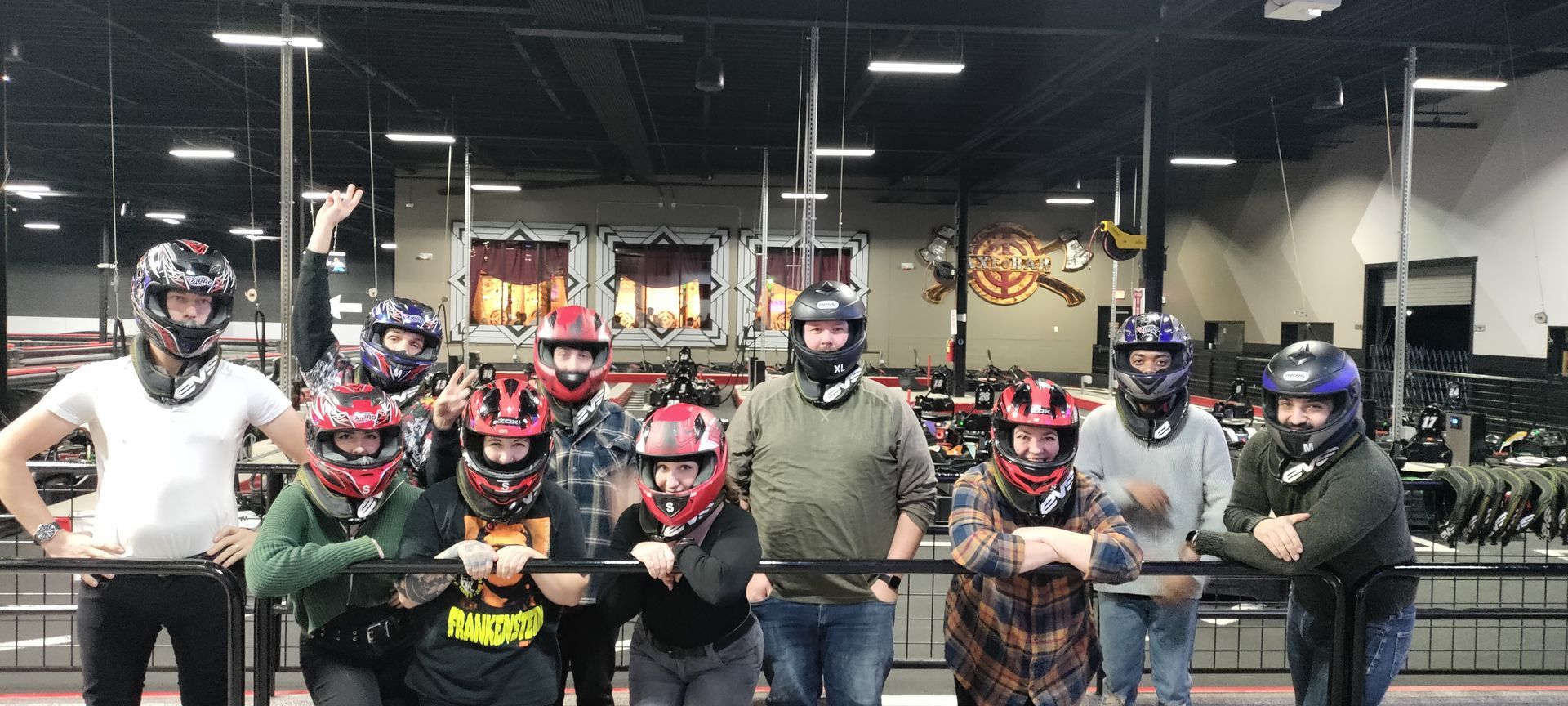 A group of people wearing helmets are standing next to each other in a room.