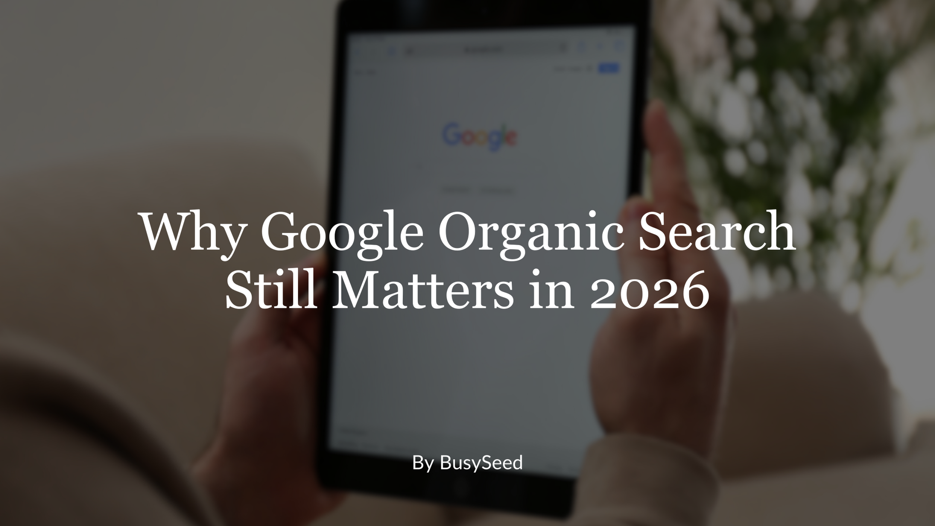 A person holds a tablet displaying a Google search page, with the overlaid text 