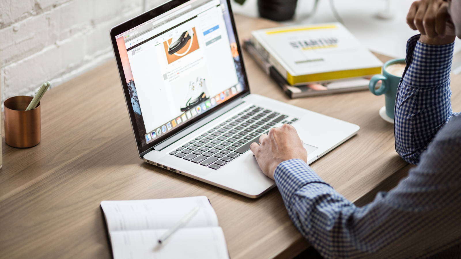 A man is sitting at a desk using a laptop computer.