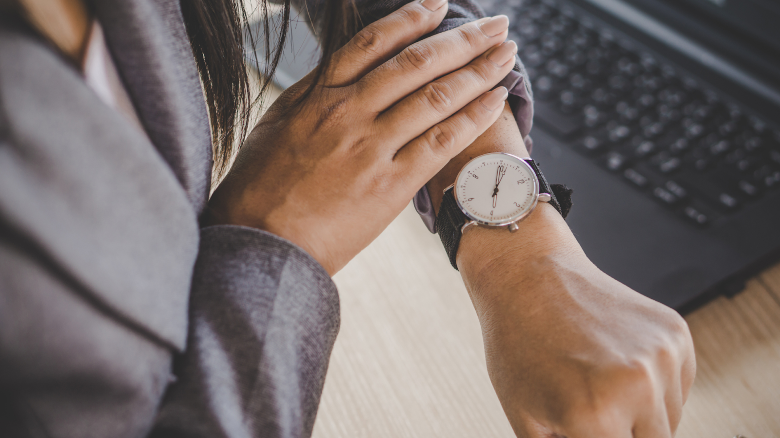 A woman is looking at her watch on her wrist.