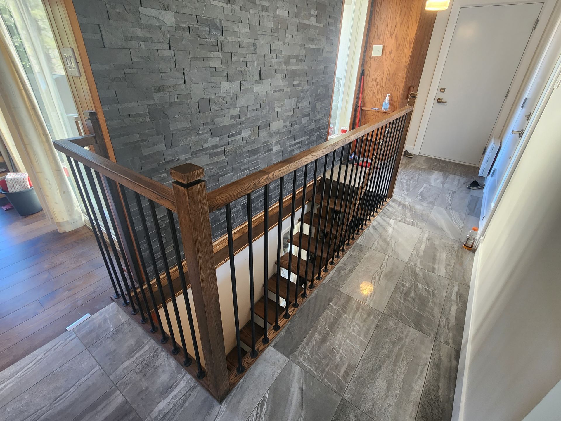 Un escalier en bois avec une rampe en métal dans un couloir.