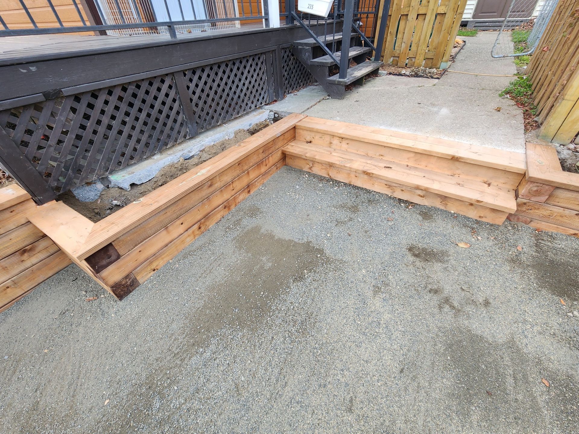 Un banc en bois est posé par terre devant une maison.