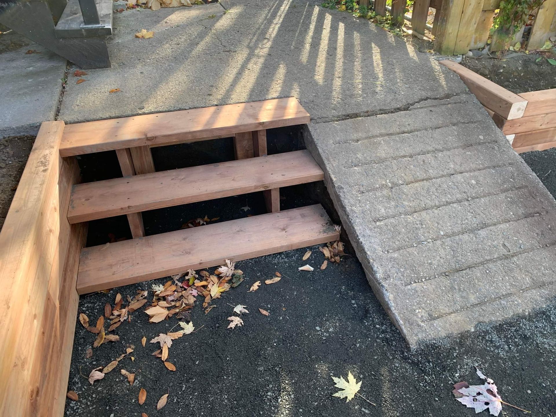 Un escalier en bois à côté d'une rampe en béton.