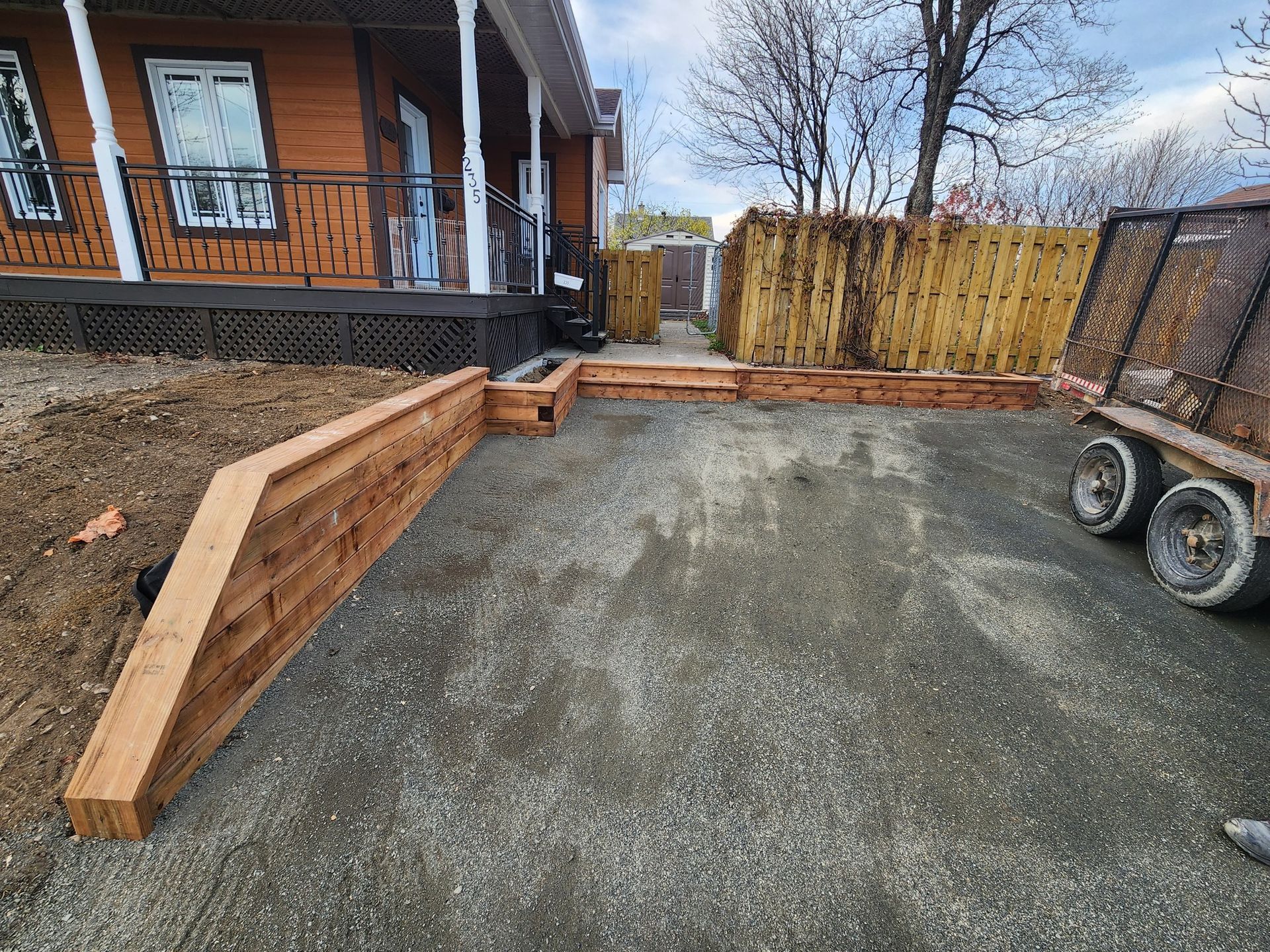 Une rampe en bois est en cours de construction devant une maison.
