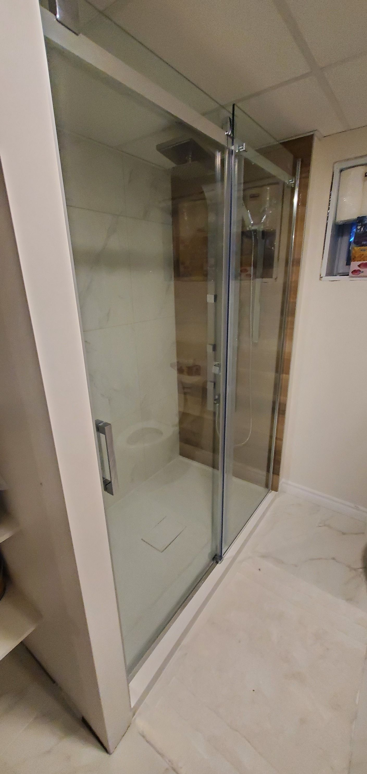 Une salle de bain avec porte de douche coulissante en verre.