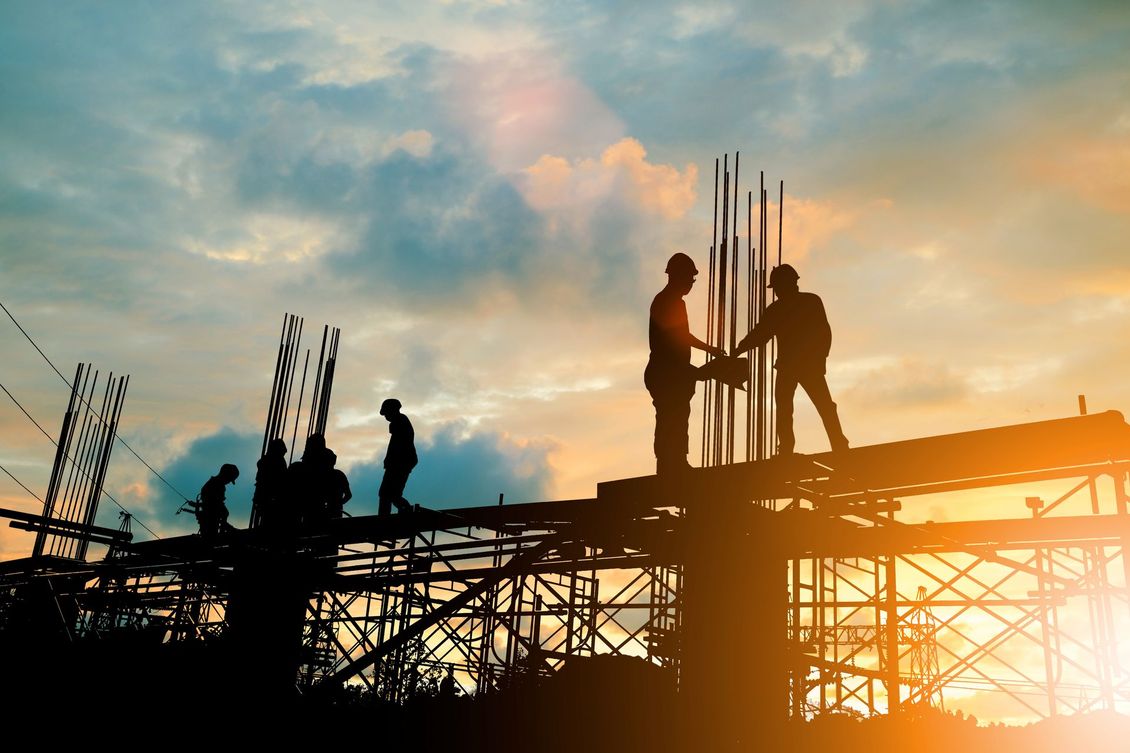 Un groupe d'ouvriers du bâtiment se serrent la main sur un chantier de construction.