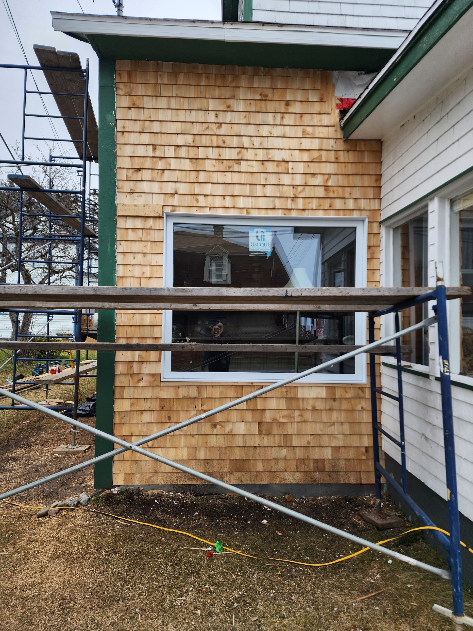 Une maison avec une fenêtre et un échafaudage devant.