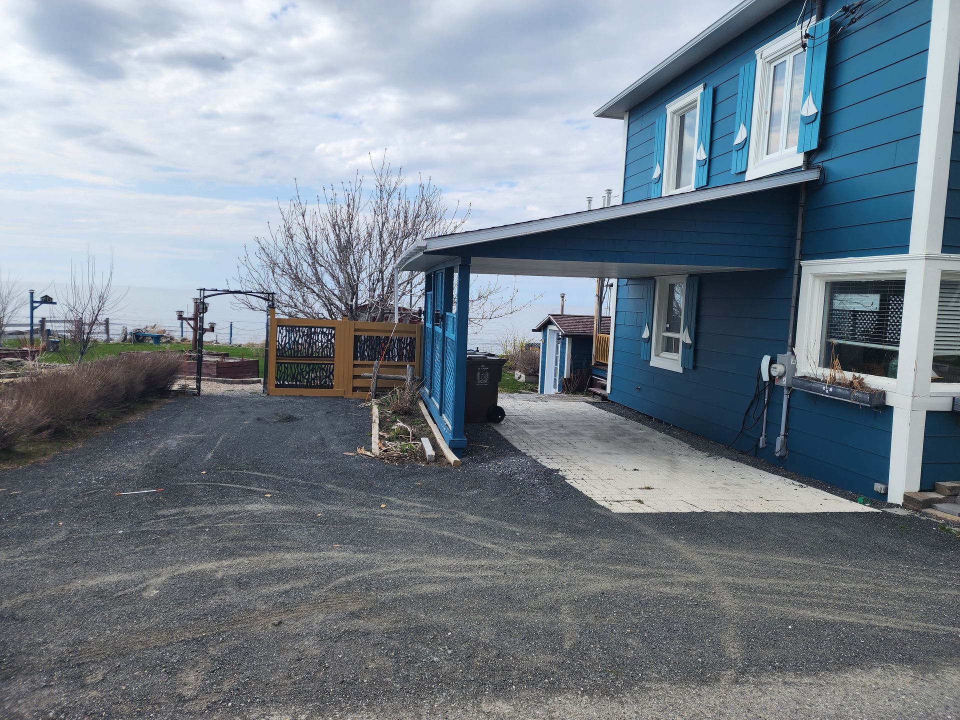 Une maison bleue et blanche avec une allée qui y mène