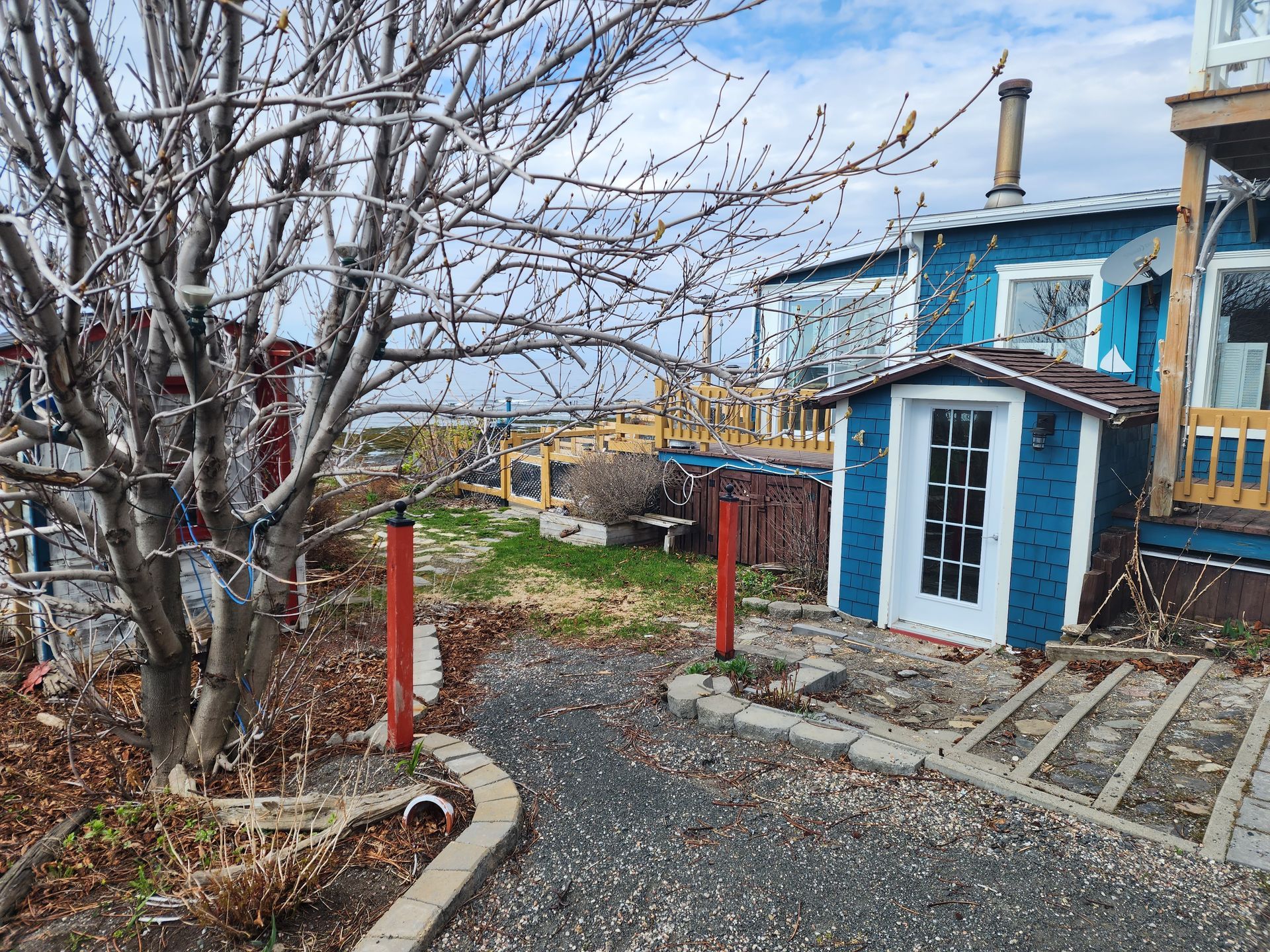 Une maison bleue avec une porte blanche et un poteau rouge devant.