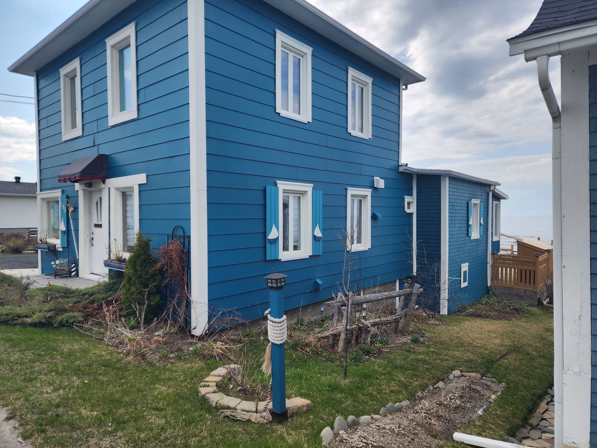 Une maison bleue et blanche avec beaucoup de fenêtres