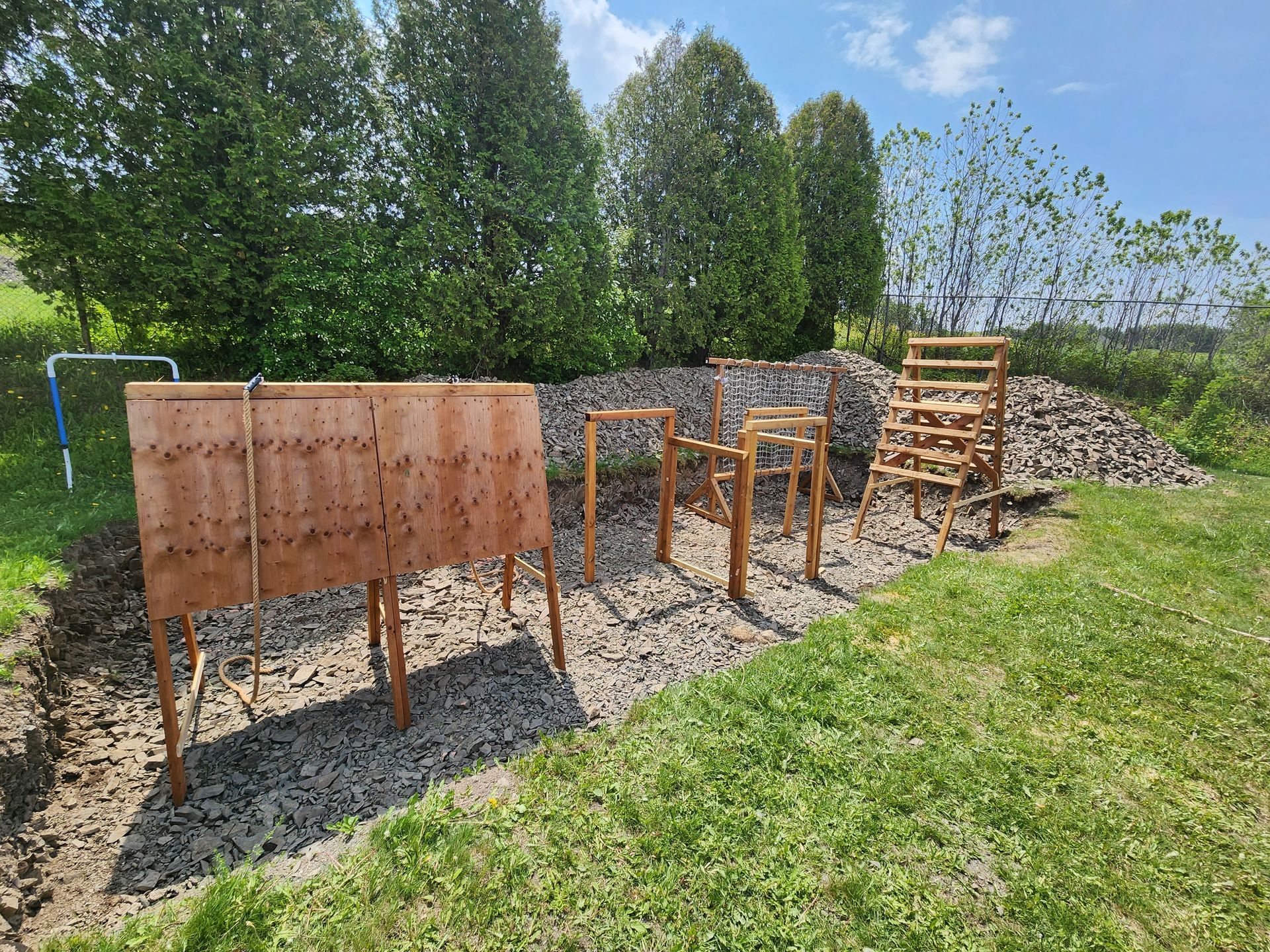 Une clôture en bois se trouve au milieu d'un champ herbeux.