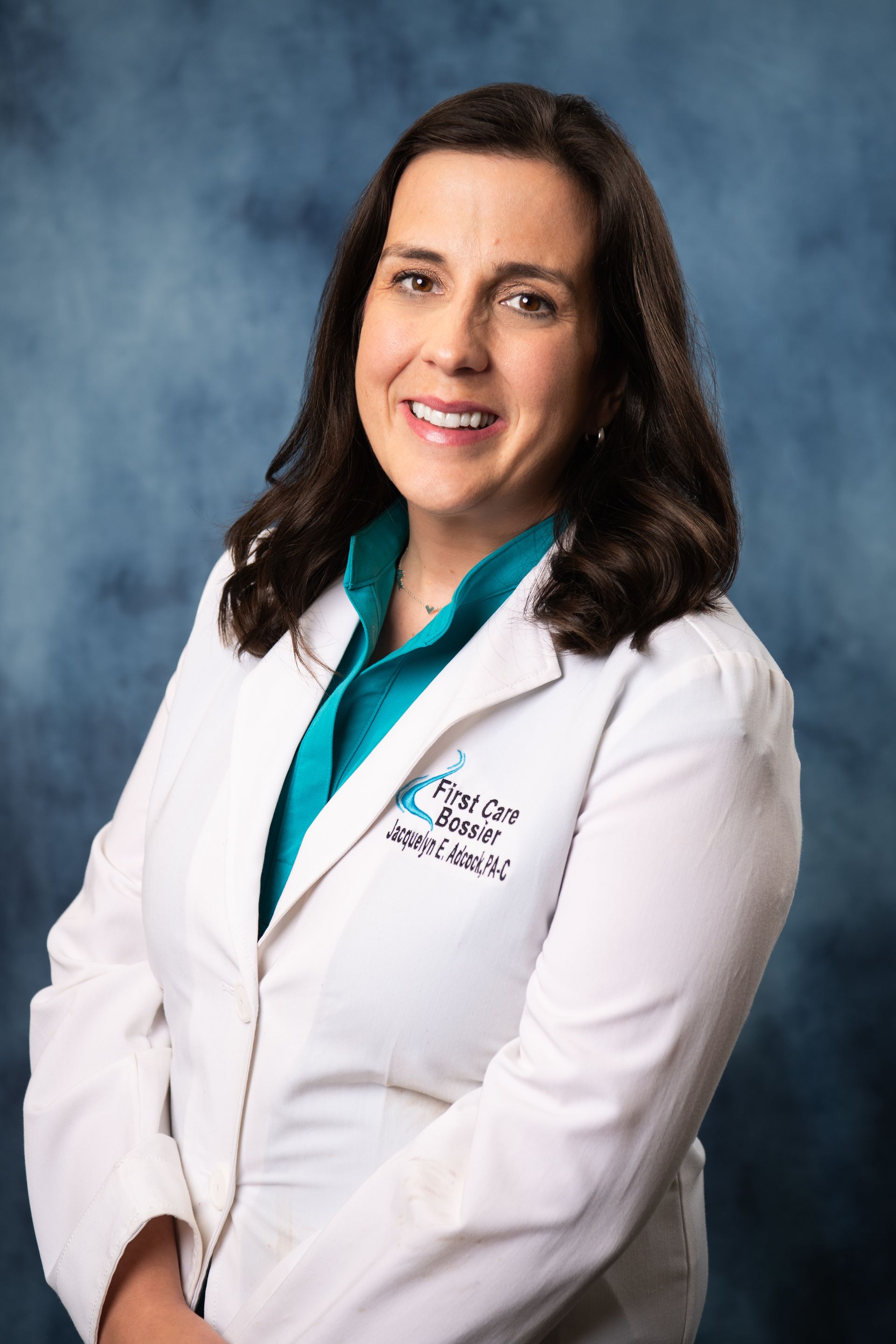A woman in a white lab coat is smiling for the camera.
